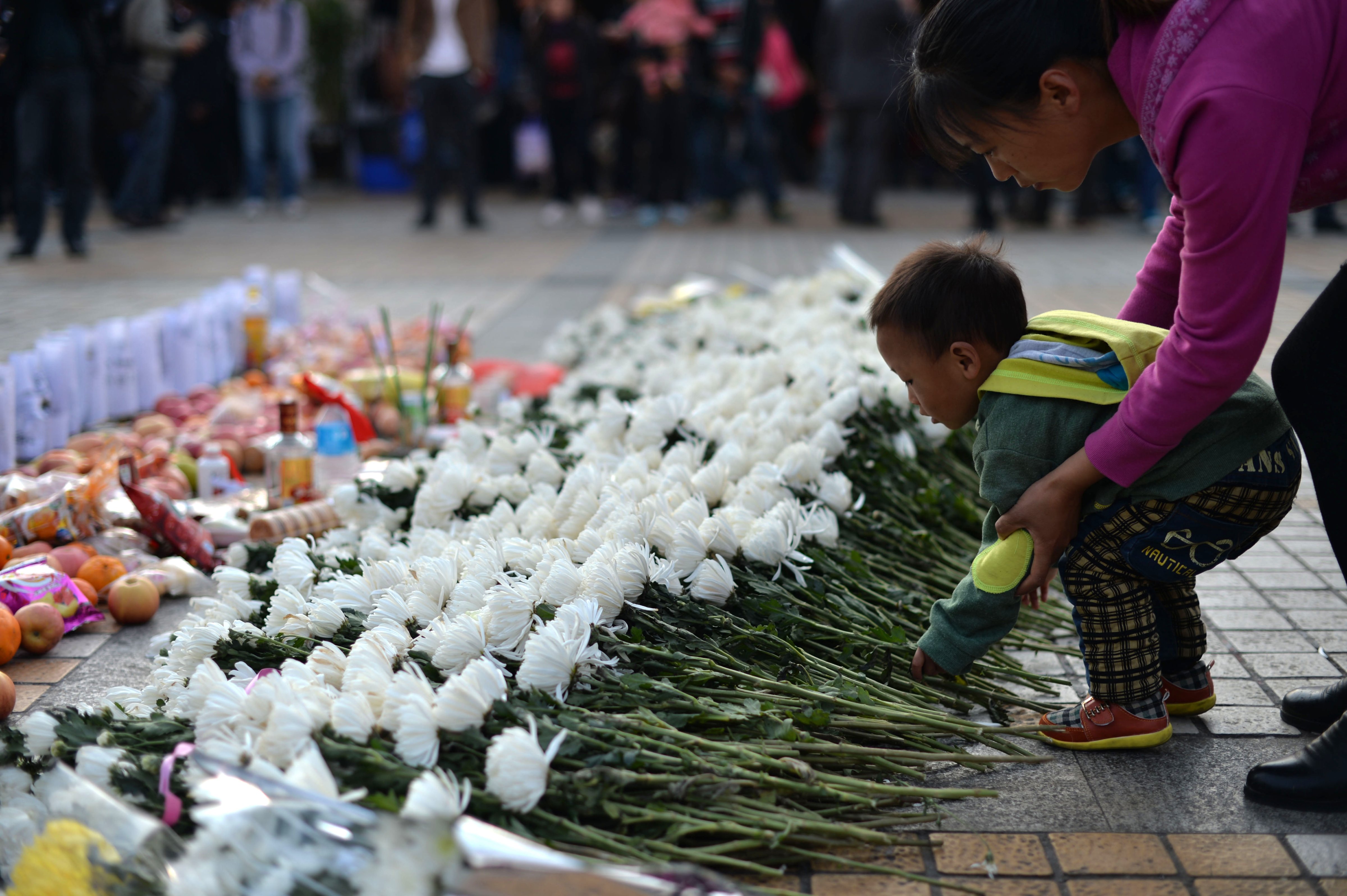This picture taken on March 7, 2014, shows a child laying a flower at the scene of a terrorist attack at the main train station in Kunming, southwest China's Yunnan province. The attack in Kunming killed 29 people and injured 143 (AFP/Getty Images)