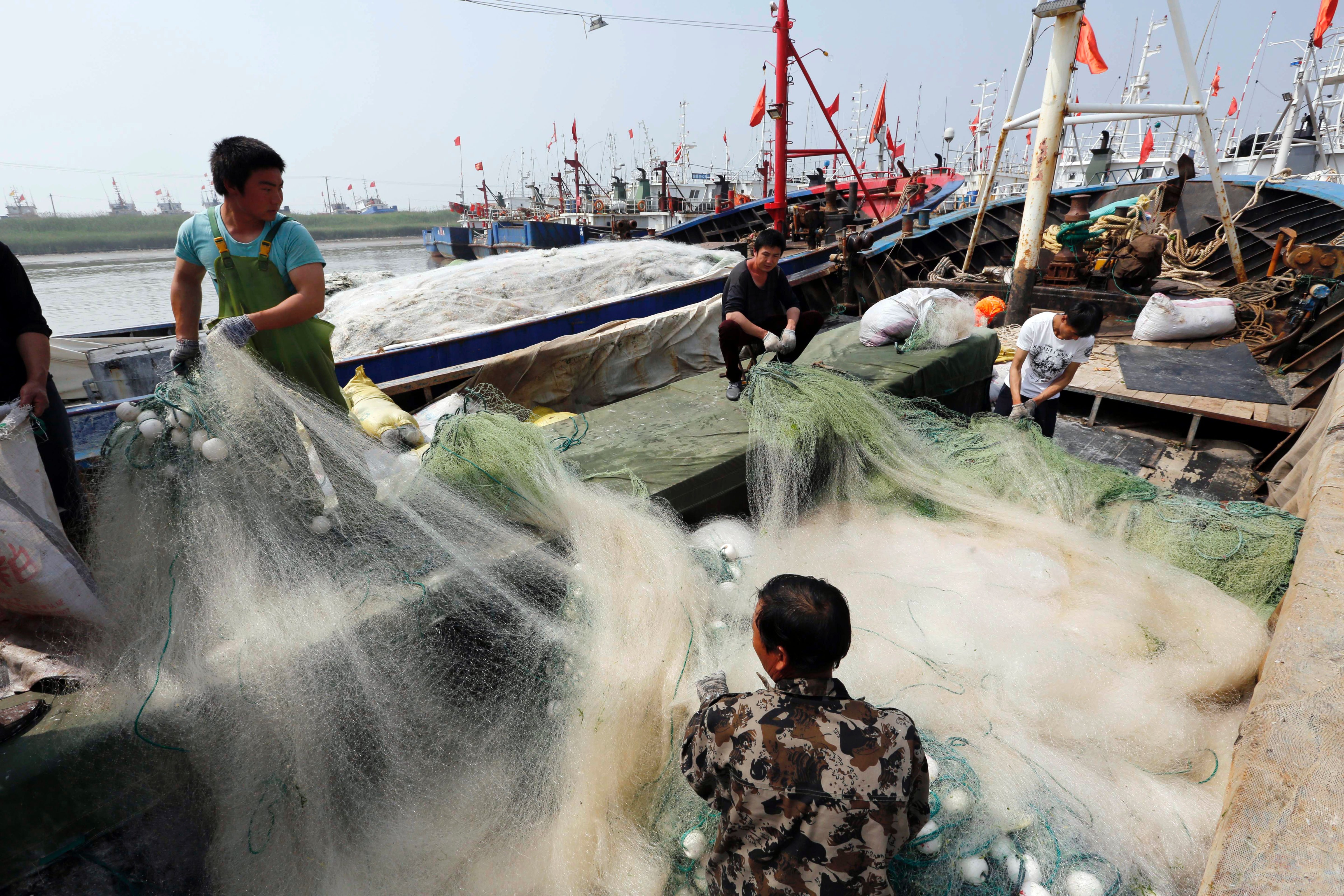 Fishermen unload fishing gear at a port in Lianyuangang, in eastern China's Jiangsu province, on May 30, 2016 (STR/AFP/Getty Images)