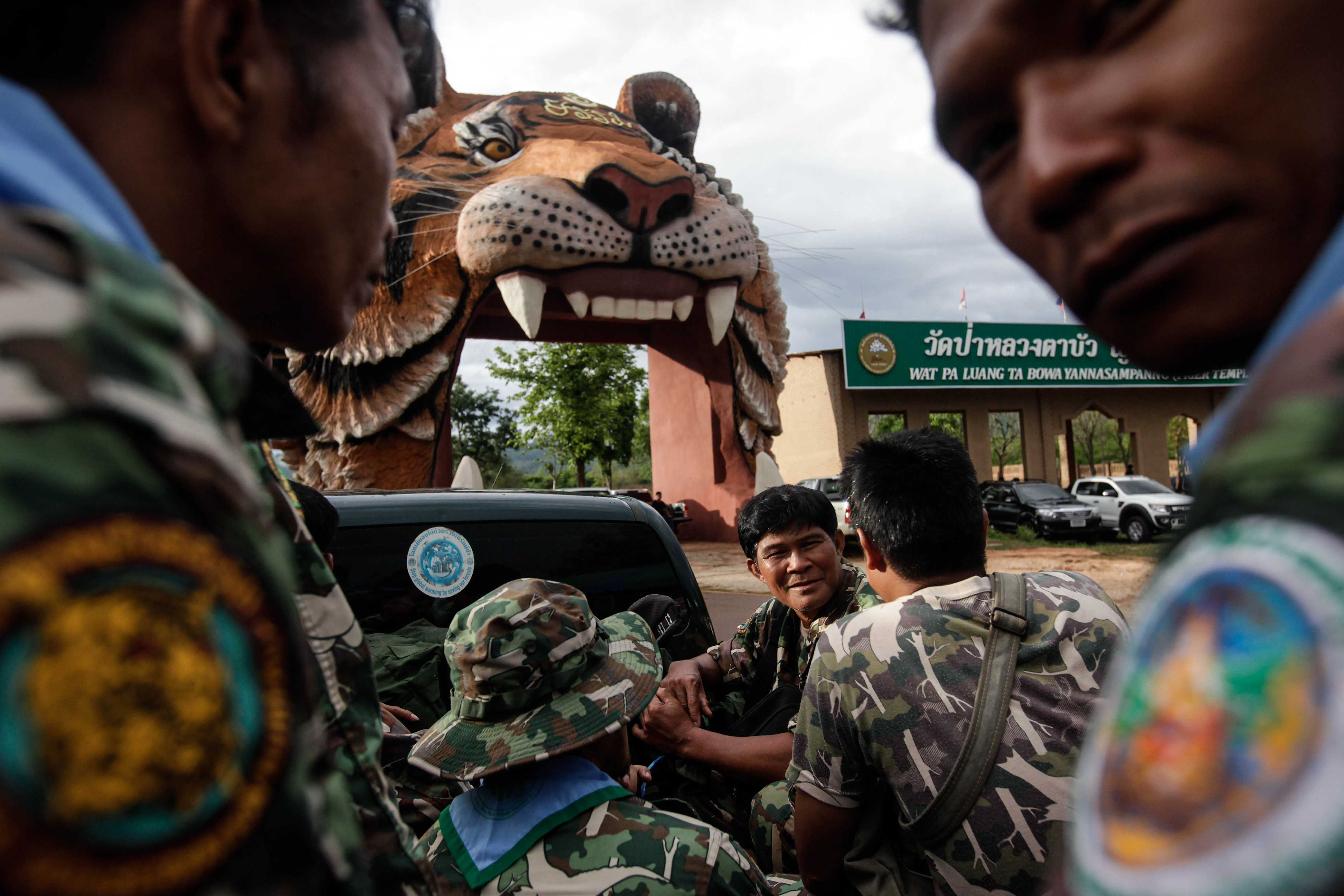 Thai DNP officers sit on a truck at the entrance of Wat Pha Luang Ta Bua Yanasampanno, or the Tiger Temple, on June 1, 2016, in Kanchanaburi province, Thailand. Wildlife authorities in Thailand have shut the temple down following accusations the monks were illegally breeding and trafficking endangered animals (Dario Pignatelli—Getty Images)