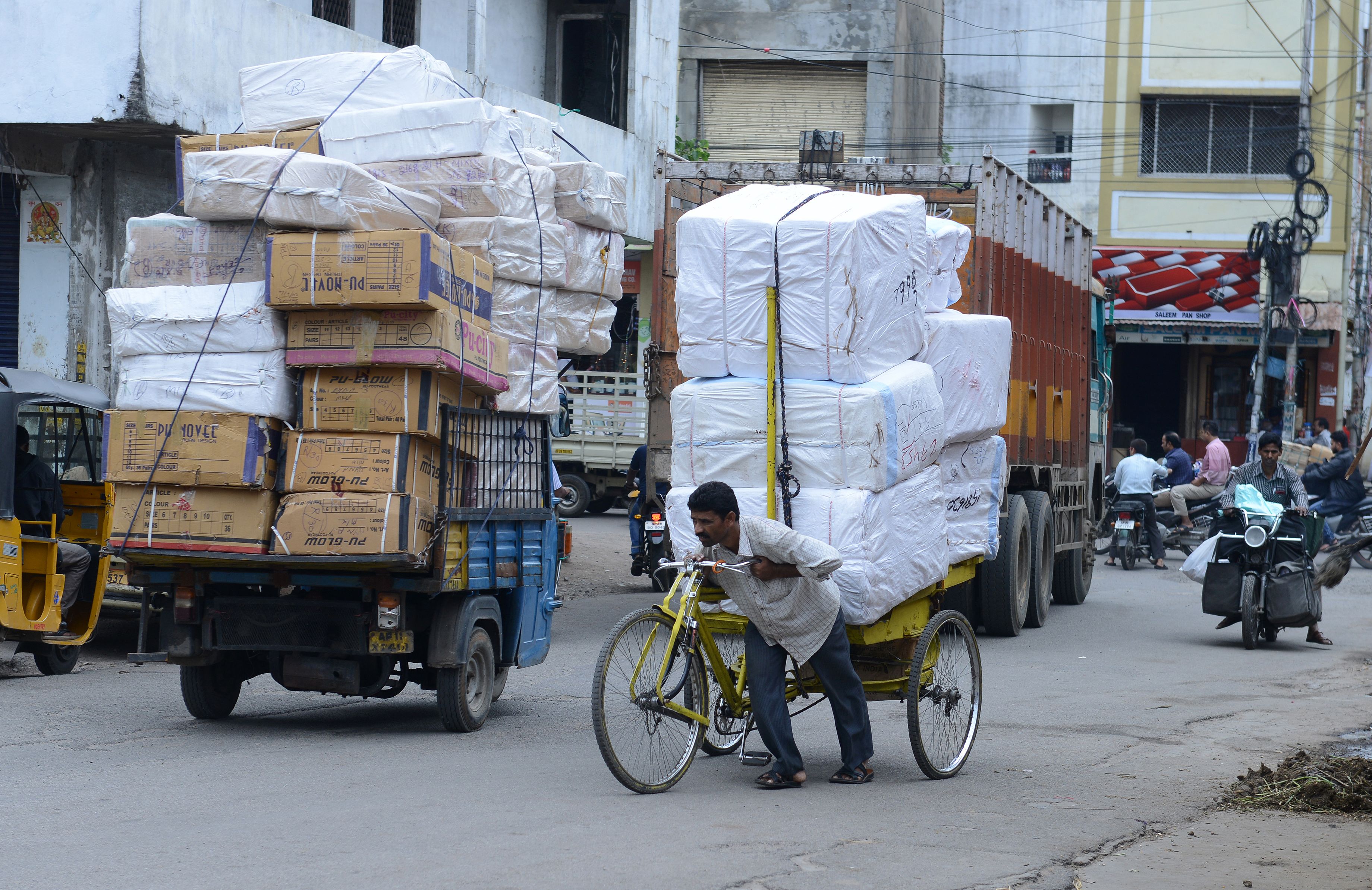 Indian labourer pushes a tri-cycle laden with consumer goods towards a wholesale shop  in Hyderabad on August 3, 2016. (Noah Seelam—FP/Getty Images)