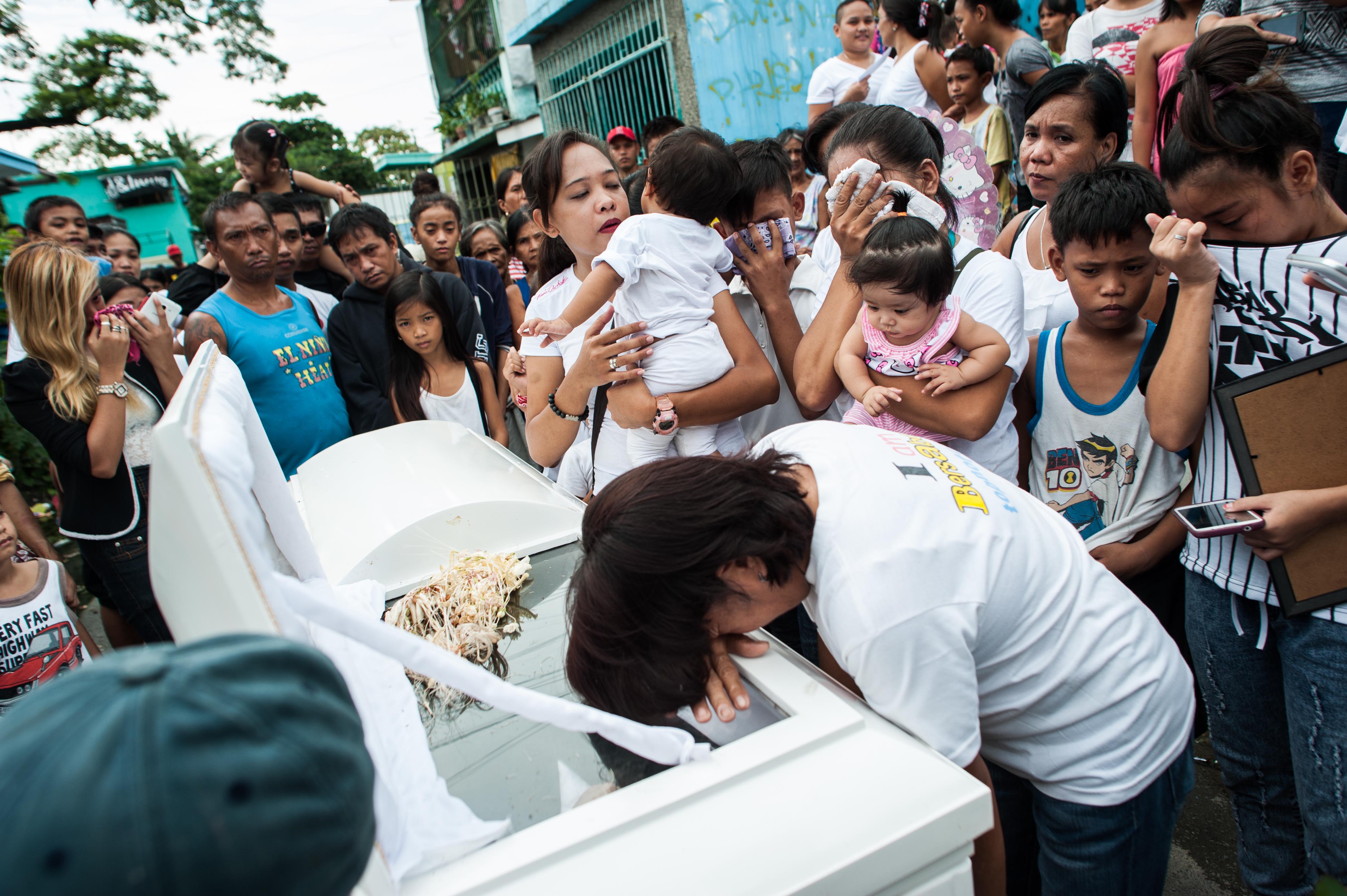 Relatives weep as the coffin of an alleged thief and drug pusher, who was a victim of an extrajudicial killing, is laid to rest on Aug. 21, 2016, in Manila (Dondi Tawatao—Getty Images)