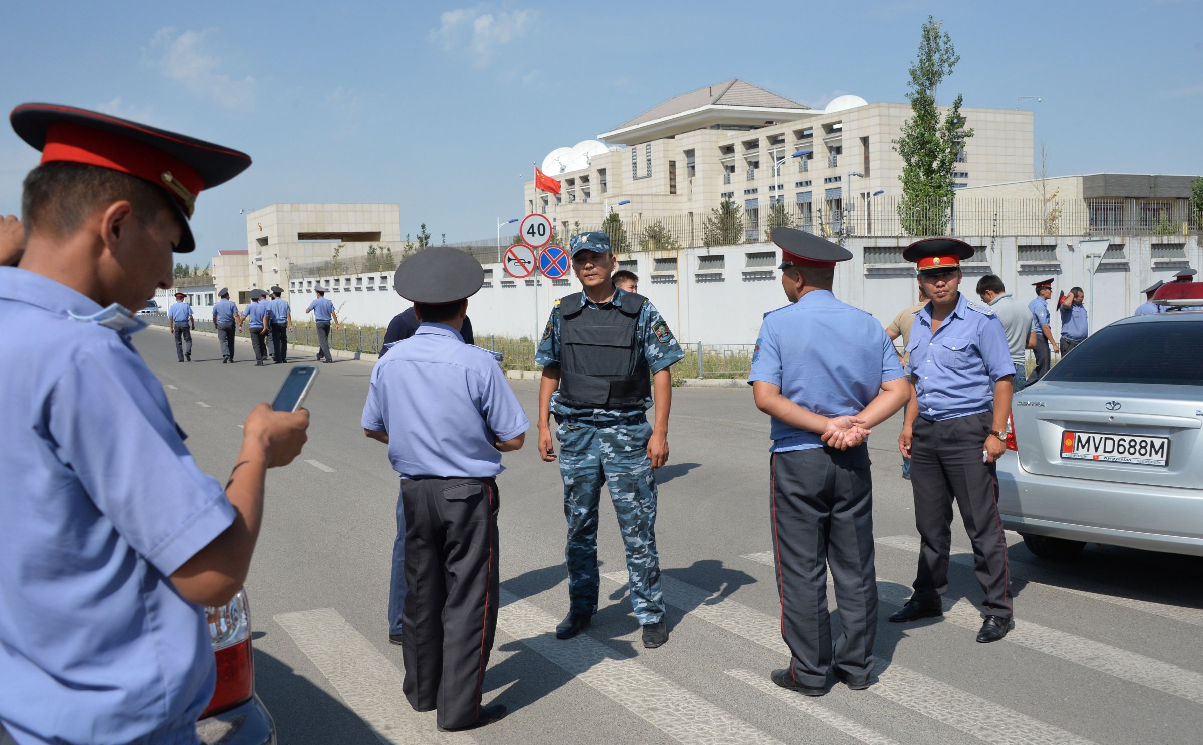 Police officers gather outside the Chinese embassy in Bishkek, Kyrgyzstan, on Aug. 30, 2016. A van driven by a suicide bomber exploded after ramming through a gate.