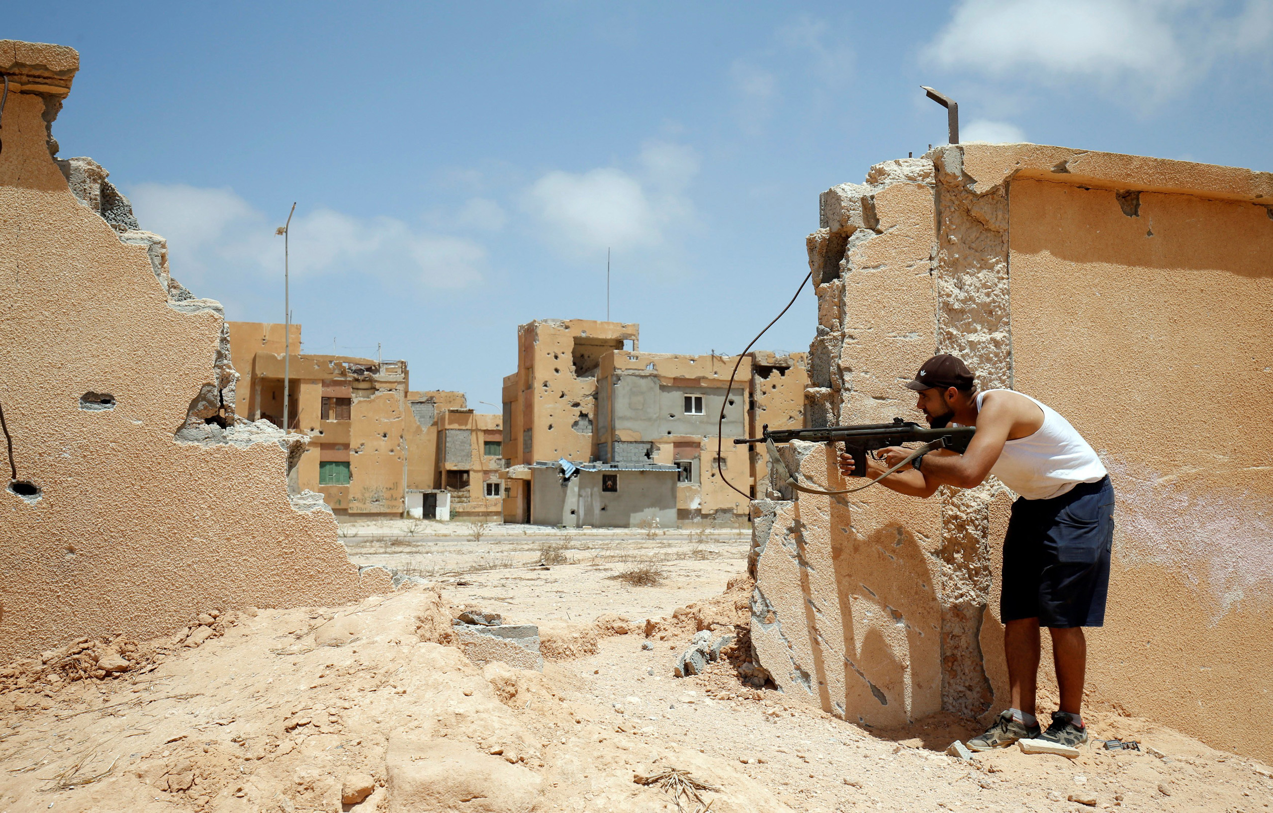 A Libyan fighters fires his gun at an ISIS position during a battle in Sirt, Libya, on July 15, 2016.