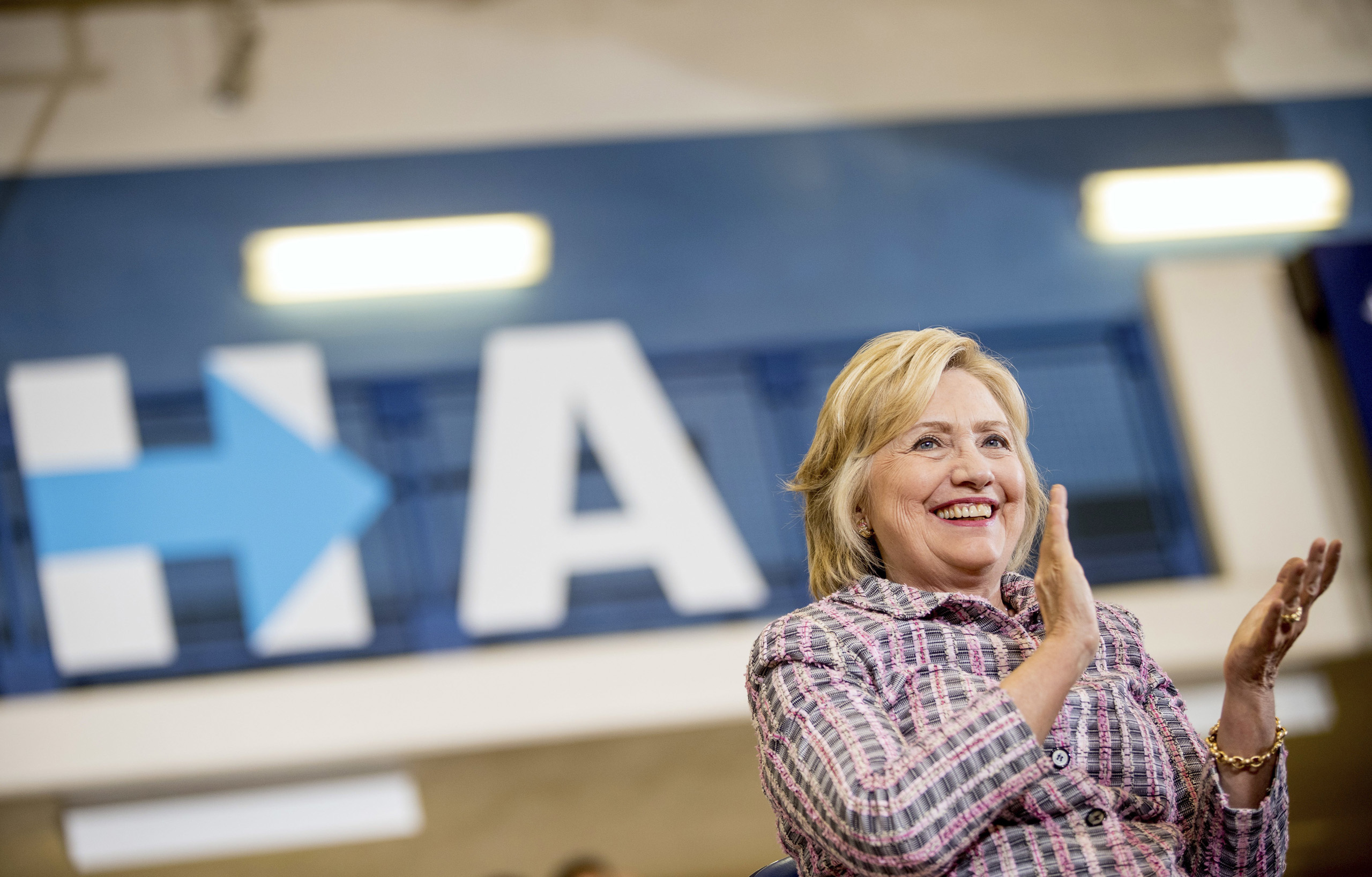 Democratic presidential candidate Hillary Clinton applauds as she sits on stage at a rally at Omaha North High Magnet School in Omaha, Neb. on Aug. 1, 2016. (Andrew Harnik—AP)
