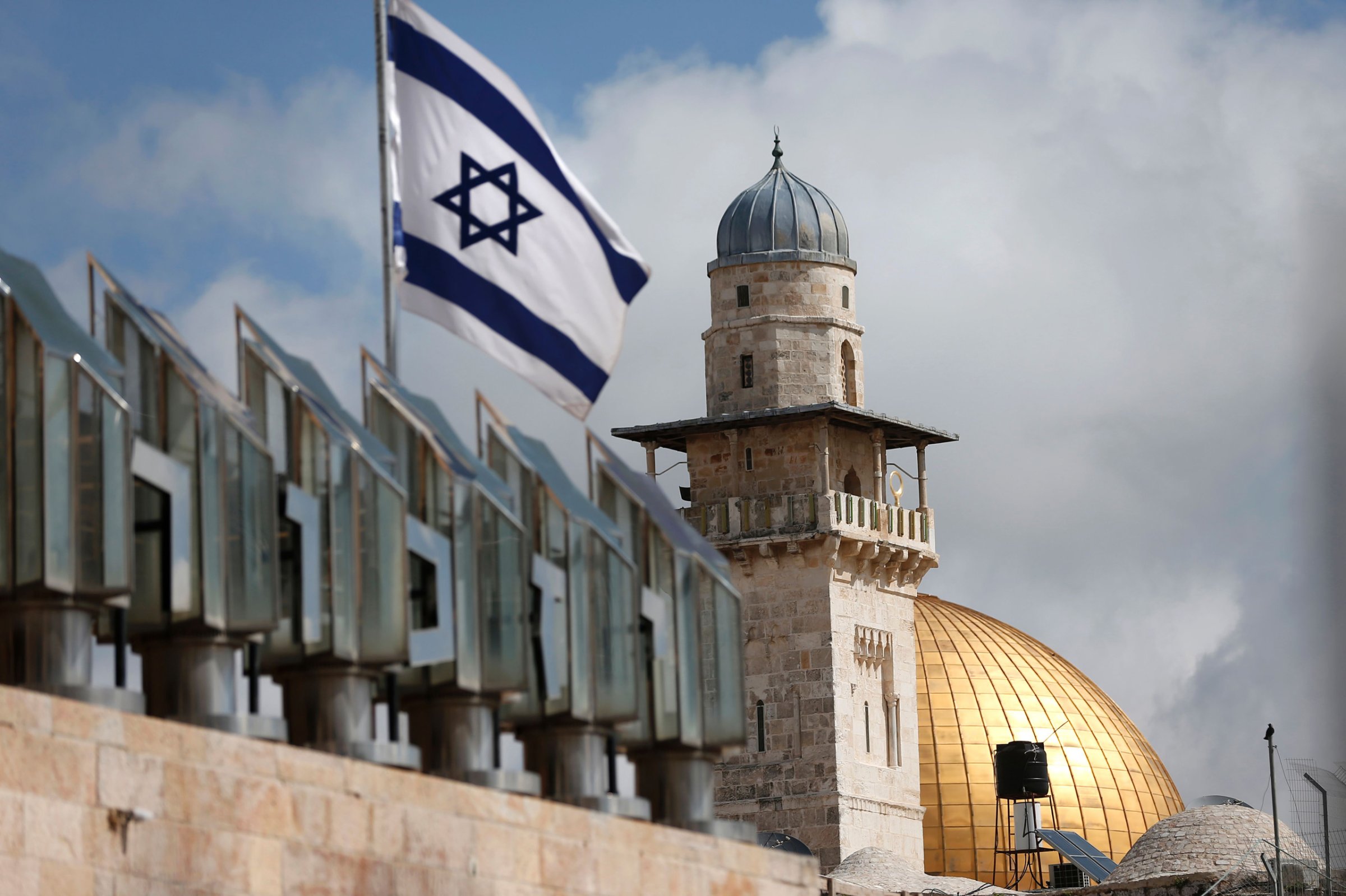 An Israeli flag is seen fleeting in front of a minaret and the Dome of the Rock on the Al-Aqsa mosque compound in Jerusalem's Old City, on March 17, 2016.