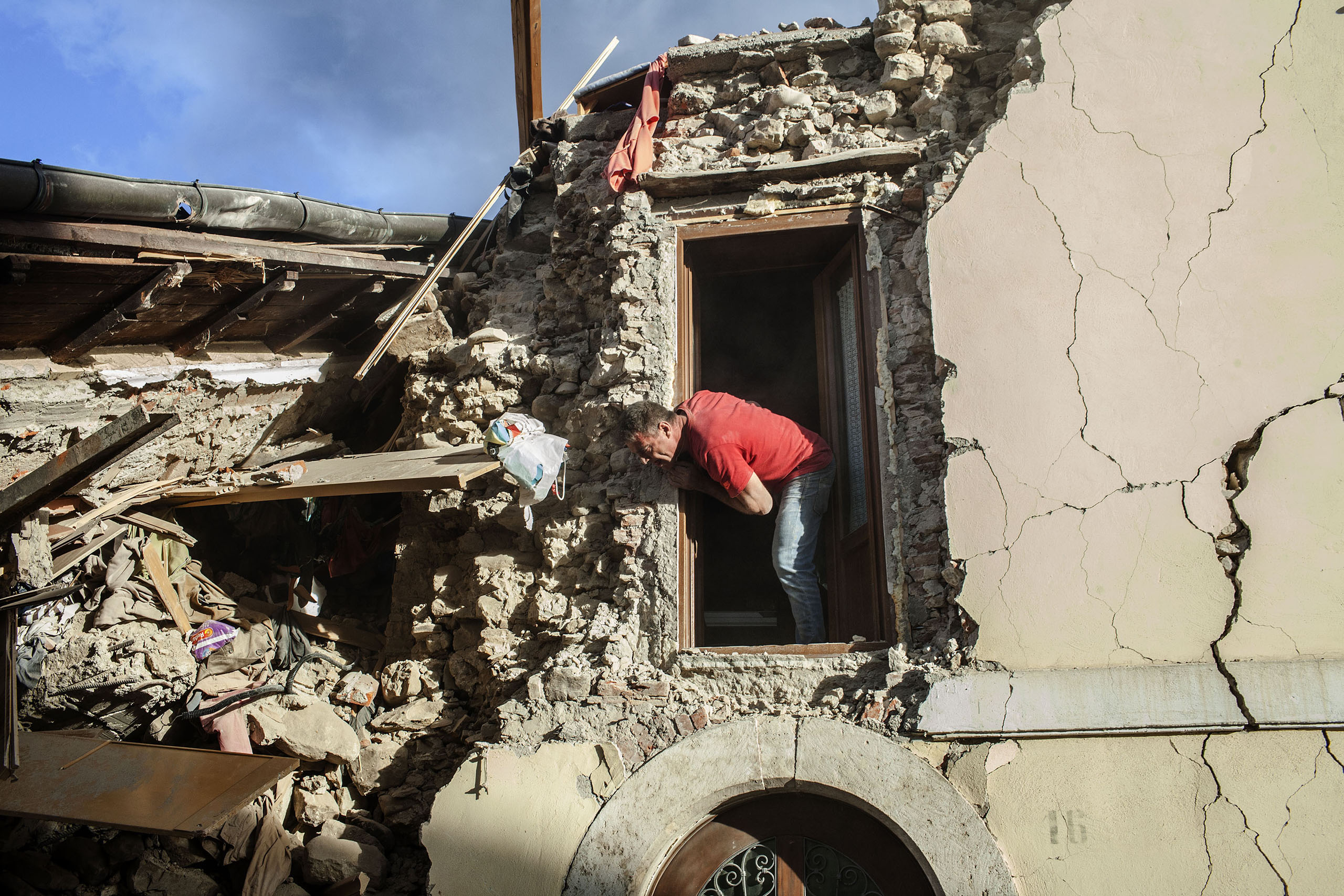 A man searches  for survivors in a house destroyed by the earthquake in Amatrice, Italy, on Aug. 24, 2016.