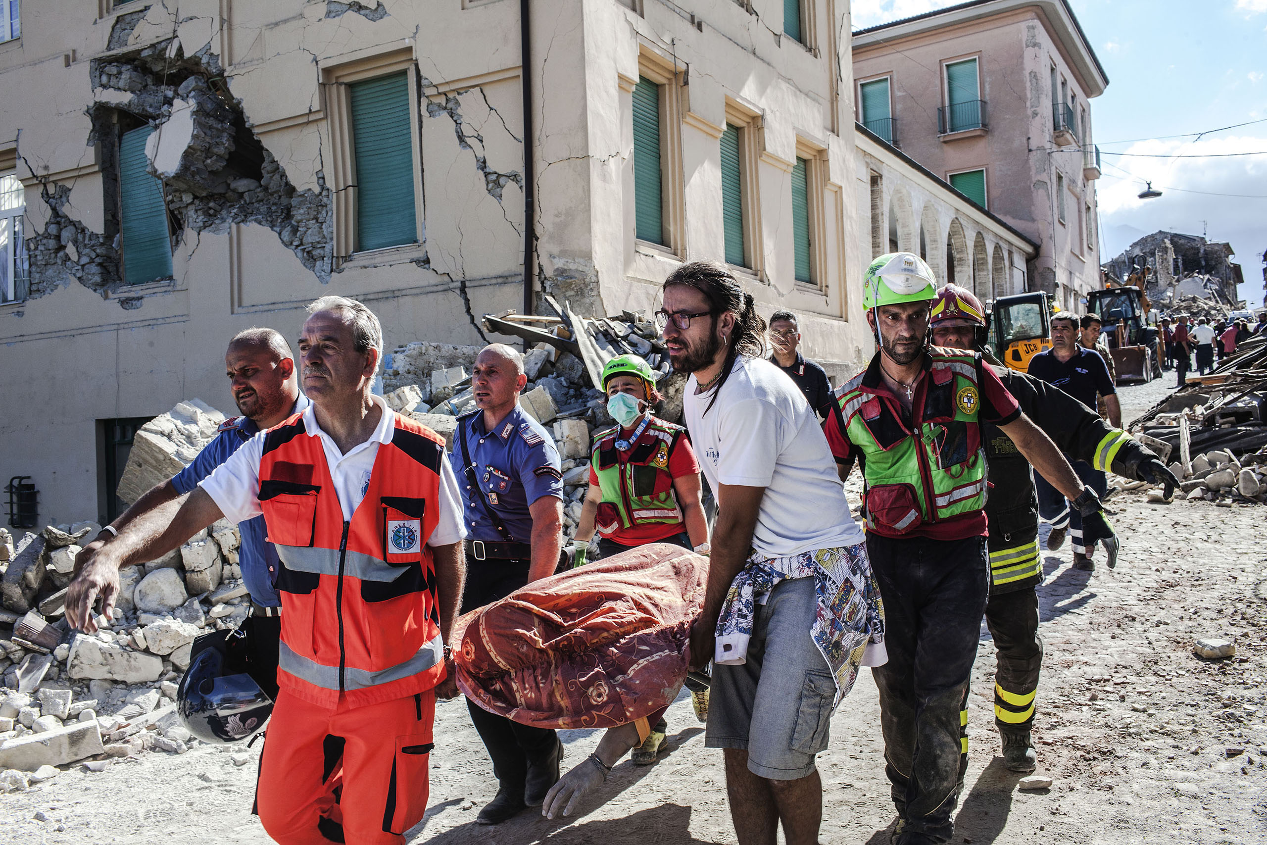 A body extracted from the rubble is carried on a stretcher in Amatrice, Italy, on Aug. 24, 2016.