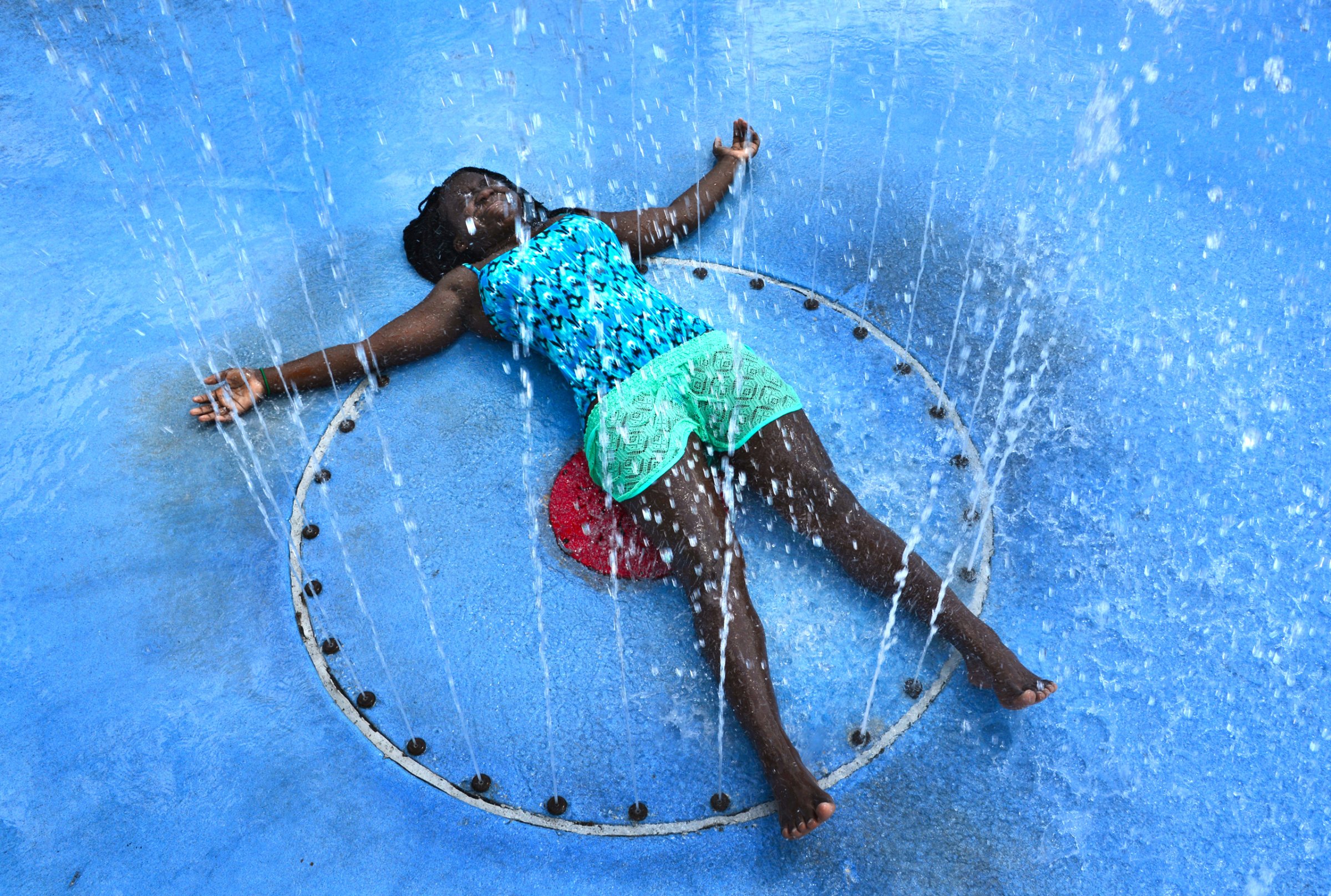 With the temperature in the mid 90's, Carliya Dove, 12, soaks up the full effects of the play fountain in Julius Guinyard Park in Jacksonville, Fla., to beat the afternoon heat on Wednesday July 20, 2016. (Bob Mack/The Florida Times-Union via AP)