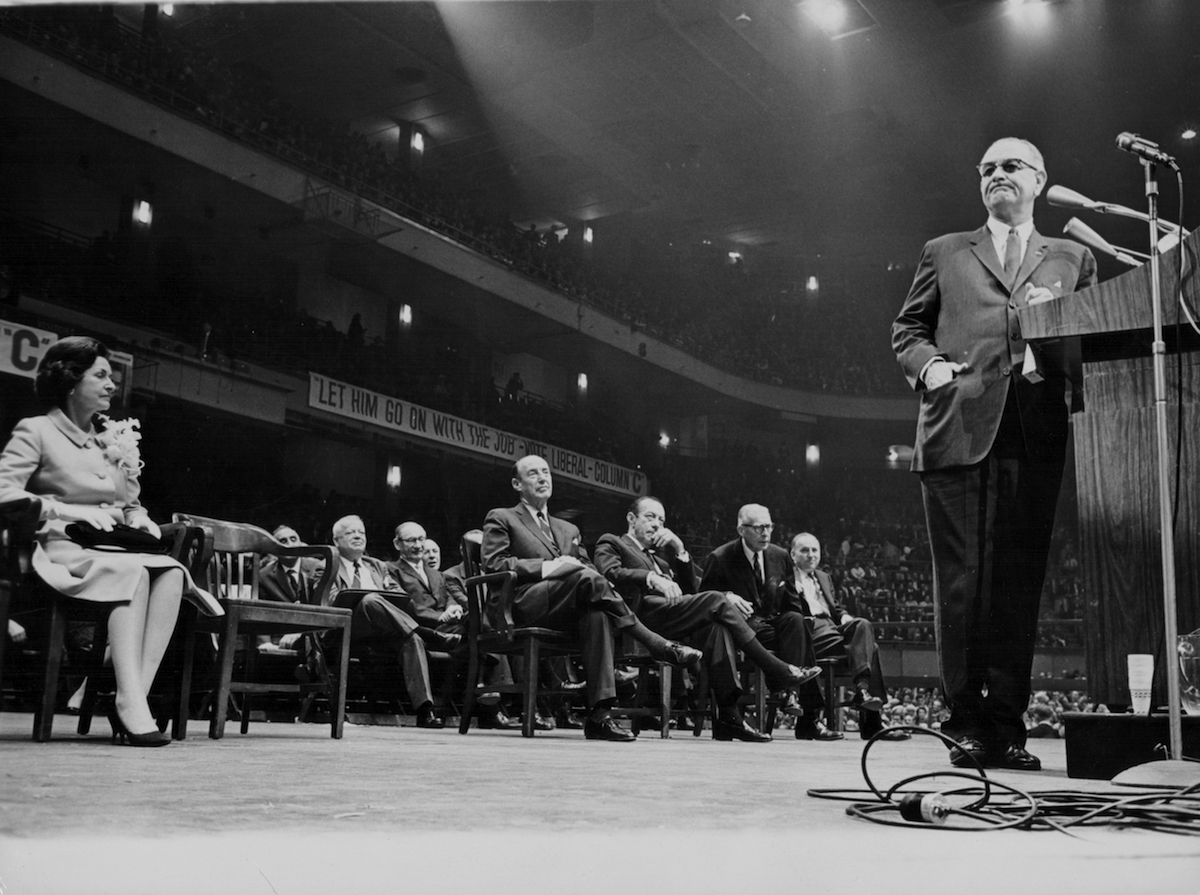 President Lyndon B Johnson addressing a rally, with his wife Lady Bird Johnson seated behind him, Madison Square Garden, New York, Oct. 21, 1964. (Keystone / Getty Images)