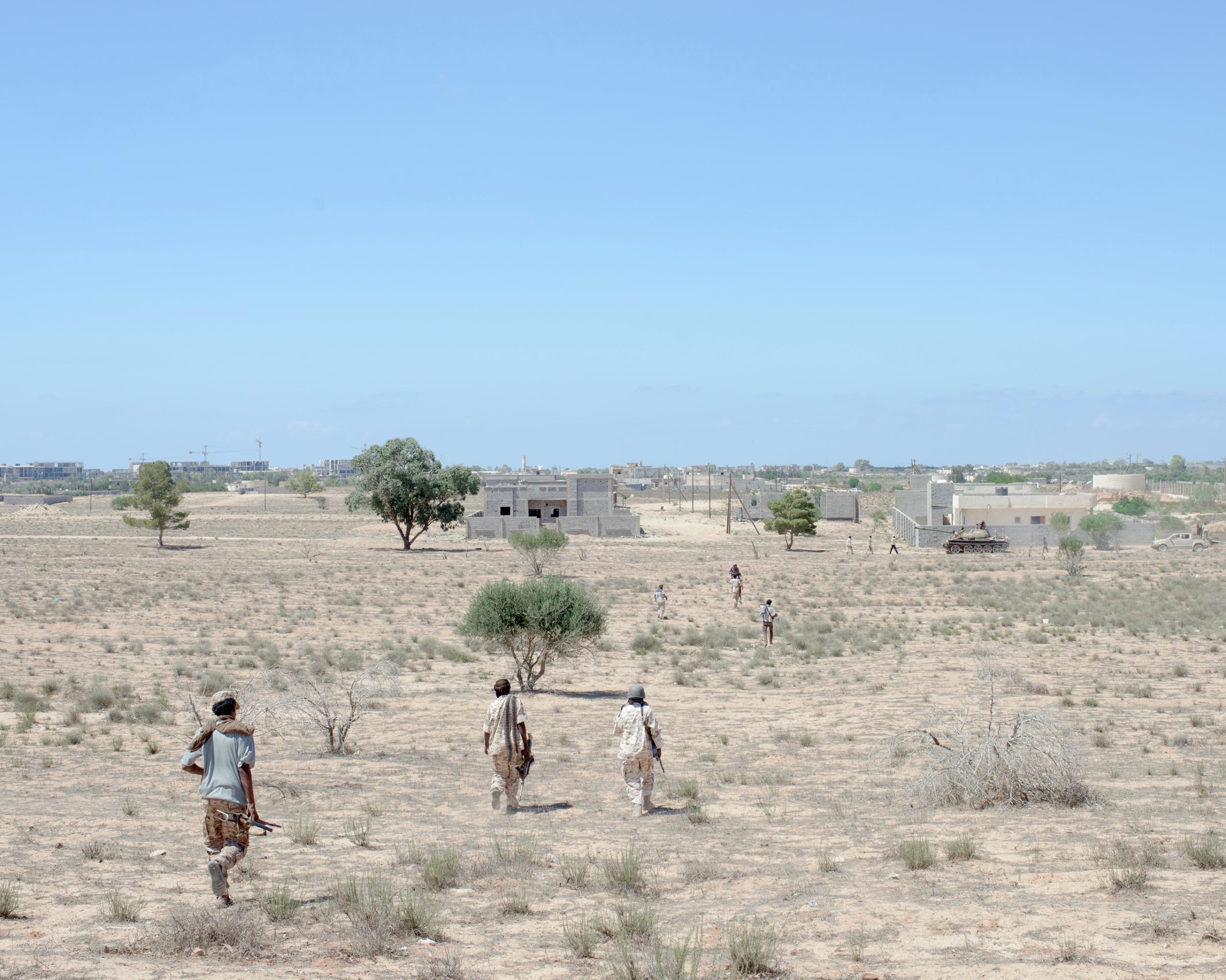 Libyan fighters advance through a minefield in the Abu Hadi district, Sirt, Libya, July 2016.