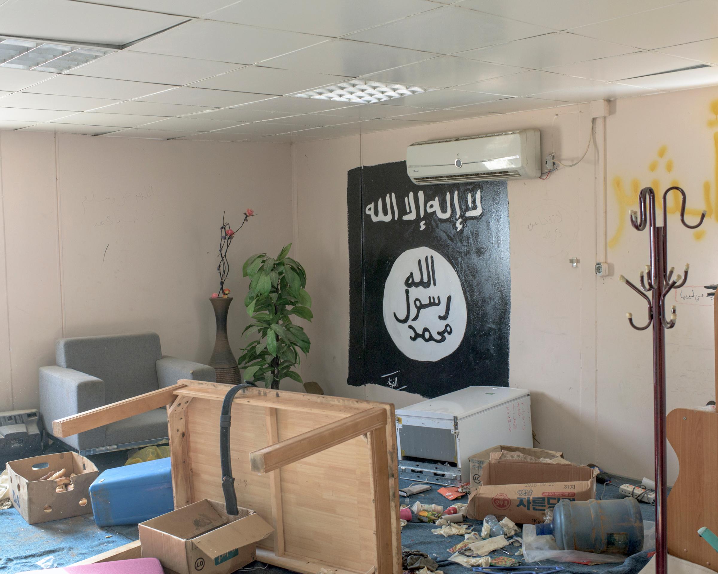 The black flag of ISIS is painted on the wall of a living room in a complex of buildings occupied by ISIS fighters, Sirt, Libya, July 2016.