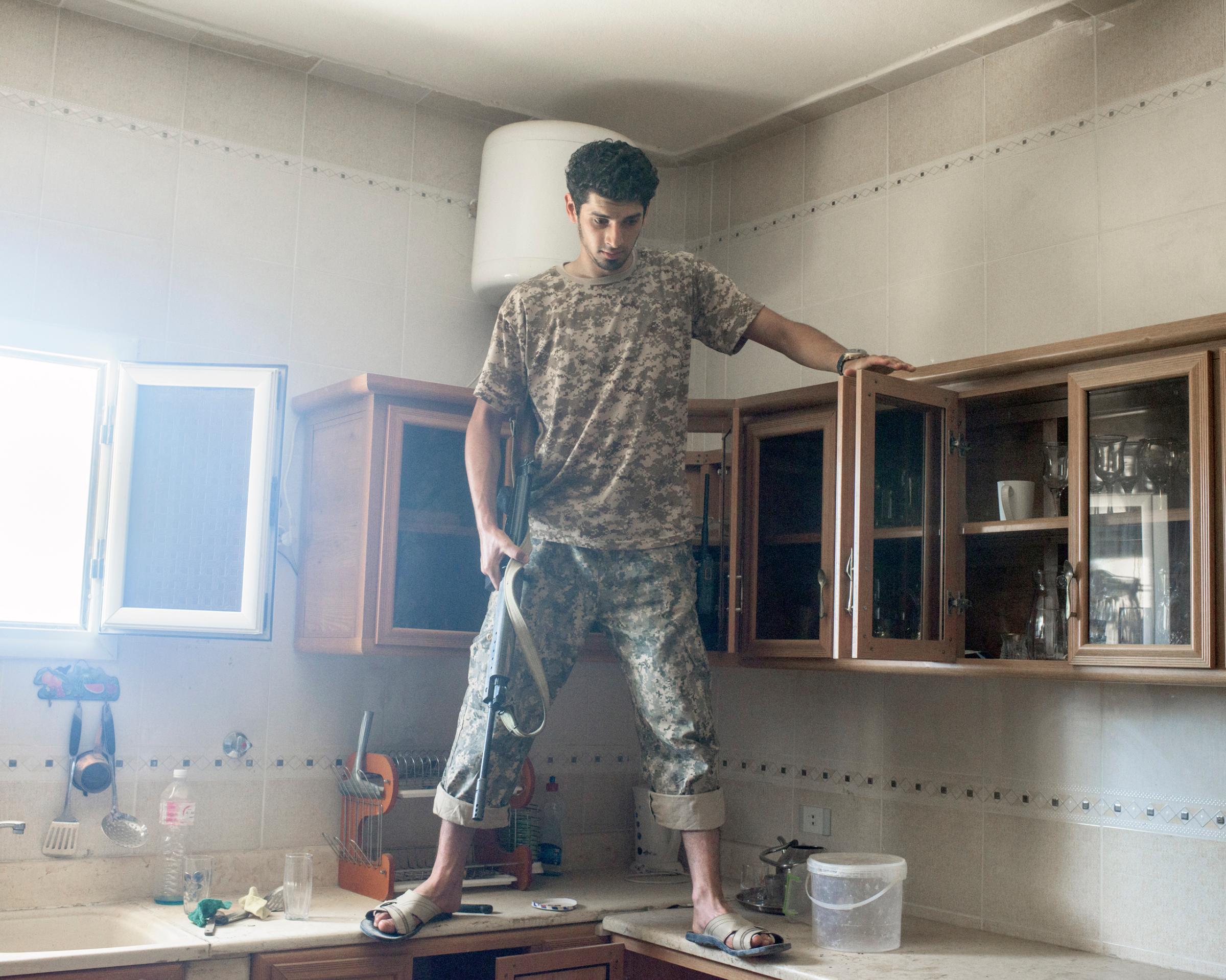 A Libyan fighter checks a kitchen for IEDs in a villa in a newly-liberated district, Sirt, Libya, July 2016.