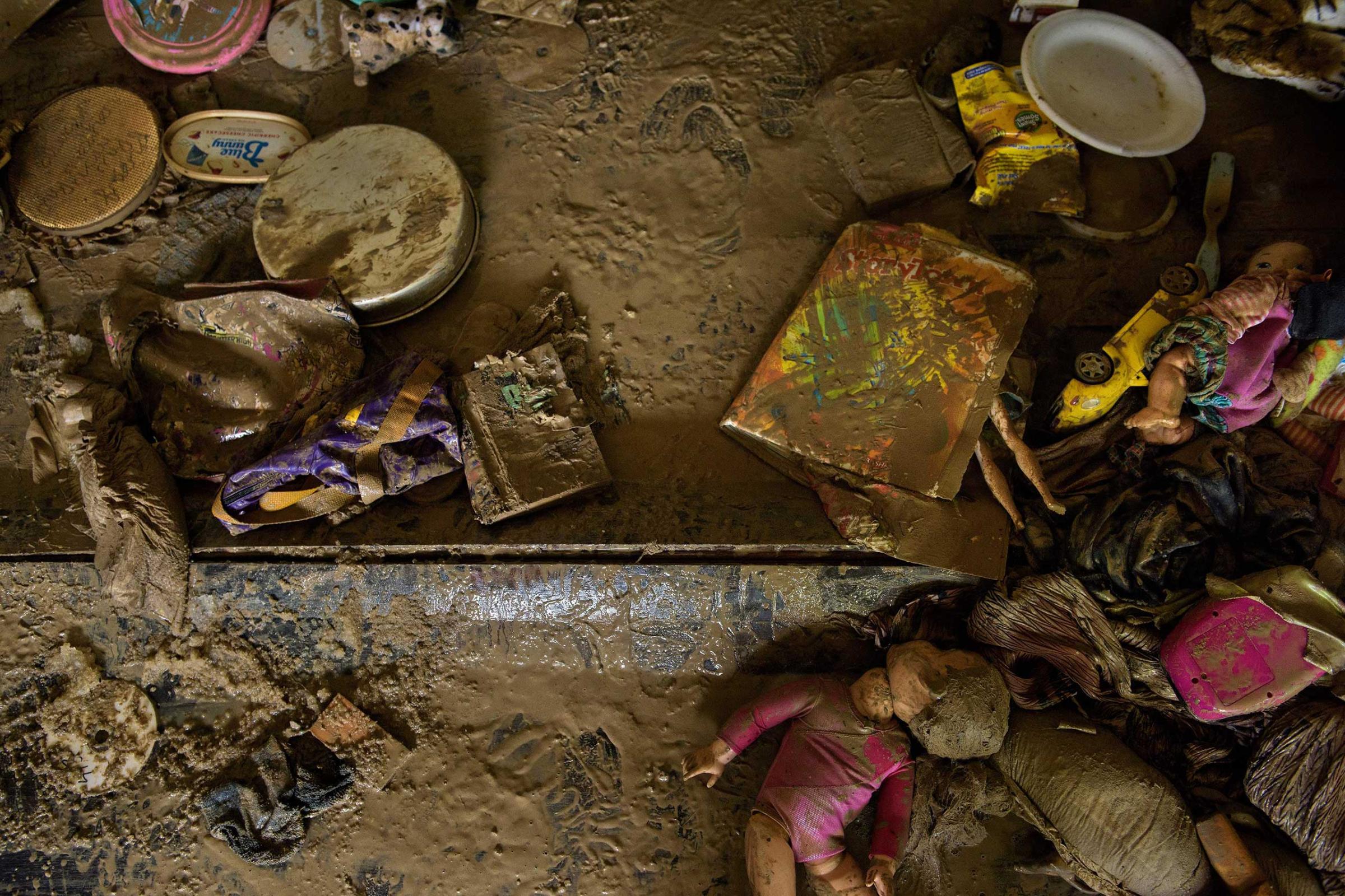 Mud covered belongings are seen on the floor of a home after floodwater receded in Denham Springs, La., on Aug. 17, 2016.