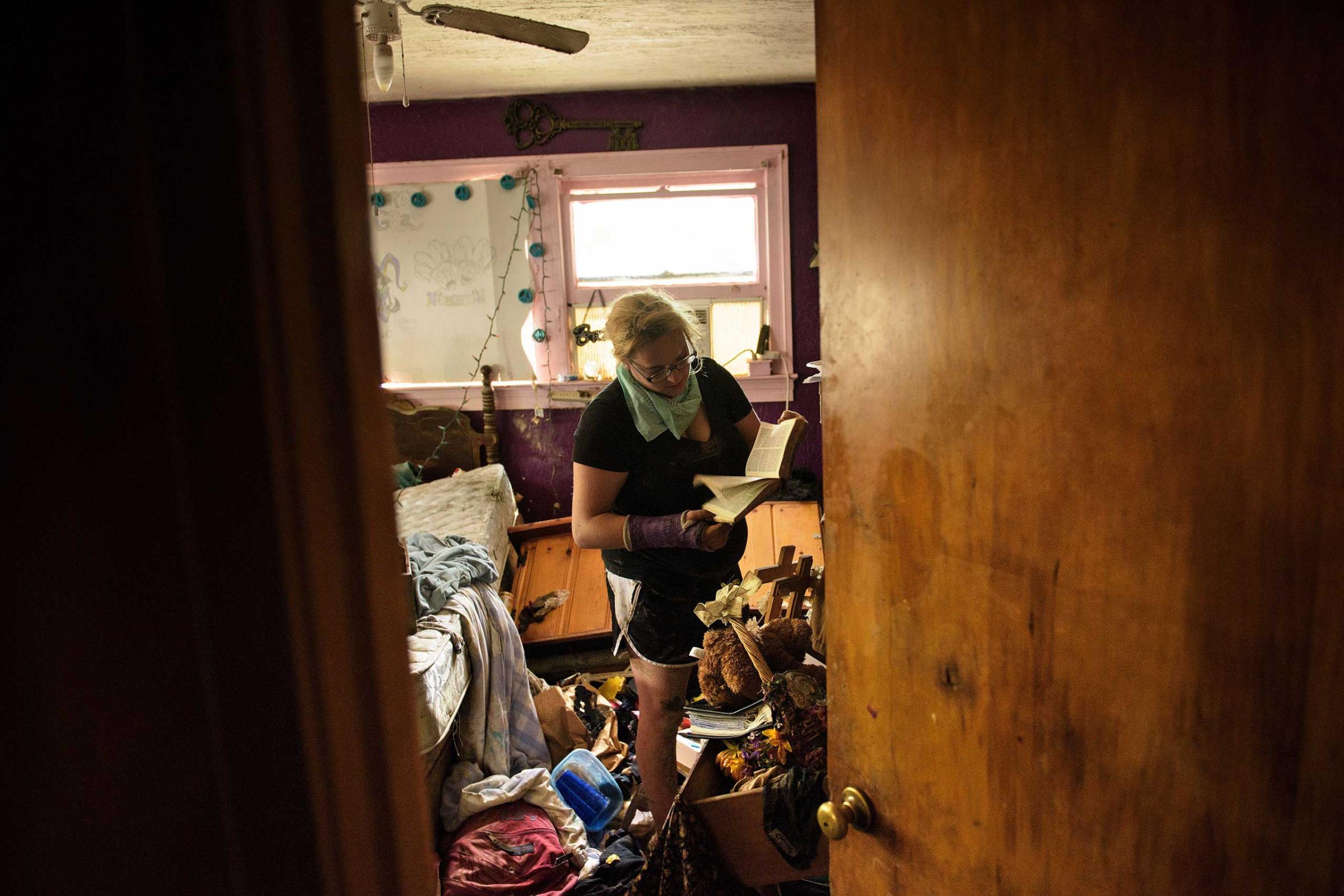 Cheyenne Hughes looks at a bible while salvaging items in her family's home after flooding in Denham, La., on Aug. 17, 2016.