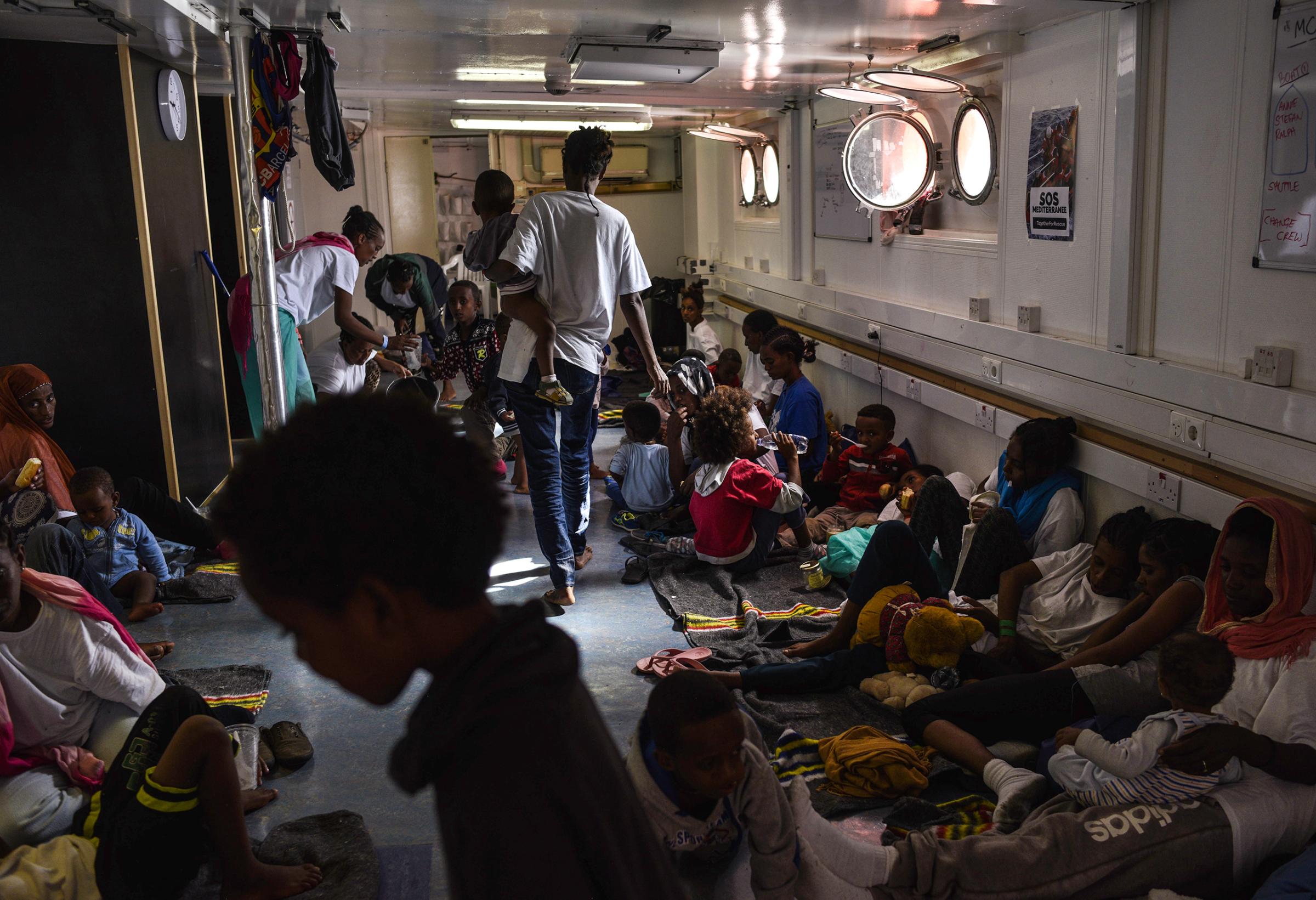 Women and children eat and rest below the deck of the rescue ship. Aug. 22, 2016.