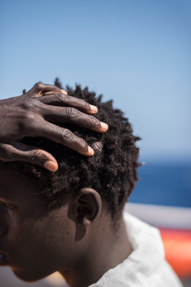 A young migrant shows off the wound on his head where he was hit by gun butts less than a week before, Aug. 22, 2016.