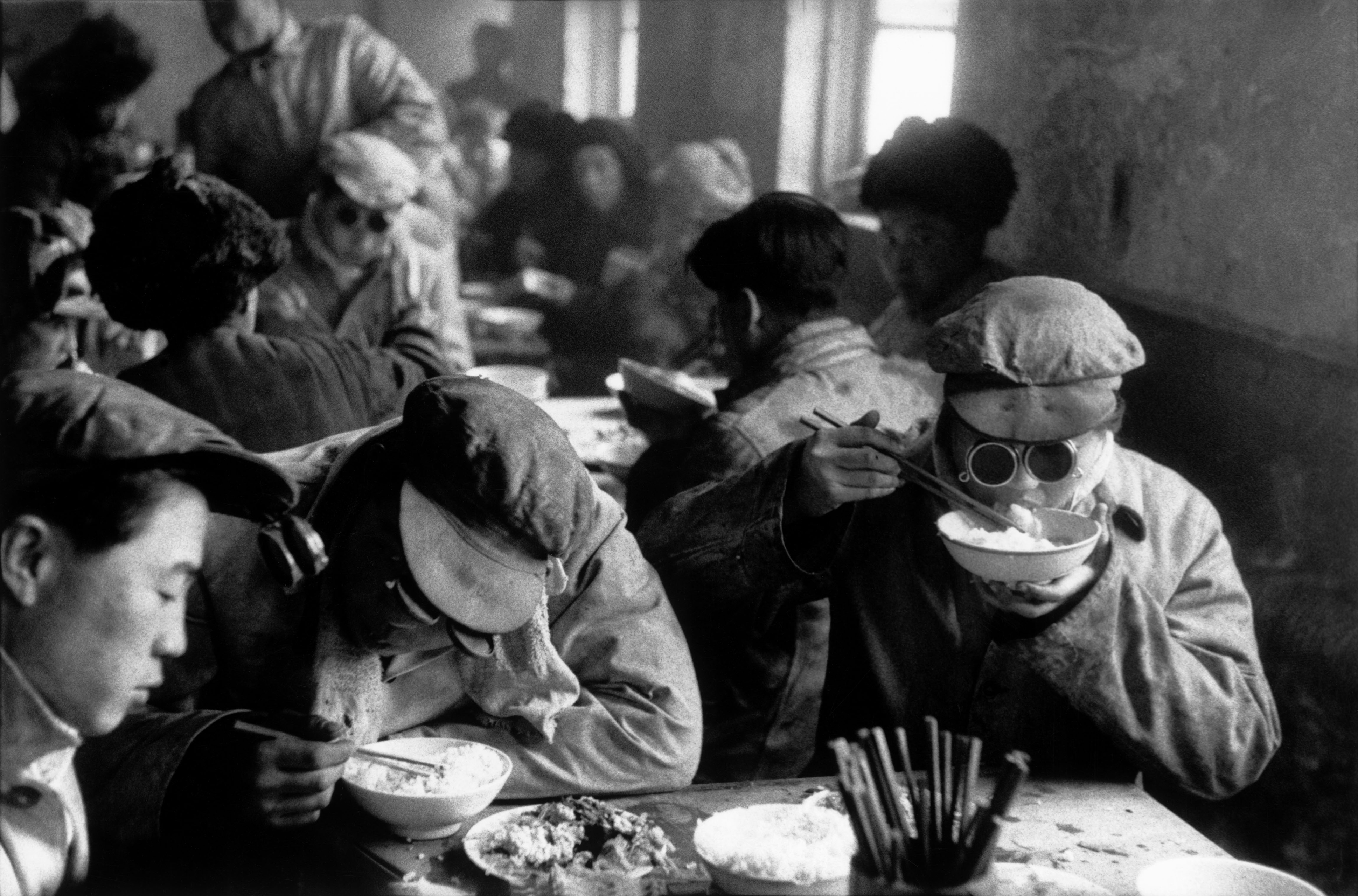 Canteen engineers have lunch while keeping their protective glasses on in a large steel mill built by the Soviets in Anshan, Liaoning province, China, 1957. As in the rest of China, it is hard to distinguish the engineers from the factory workers.