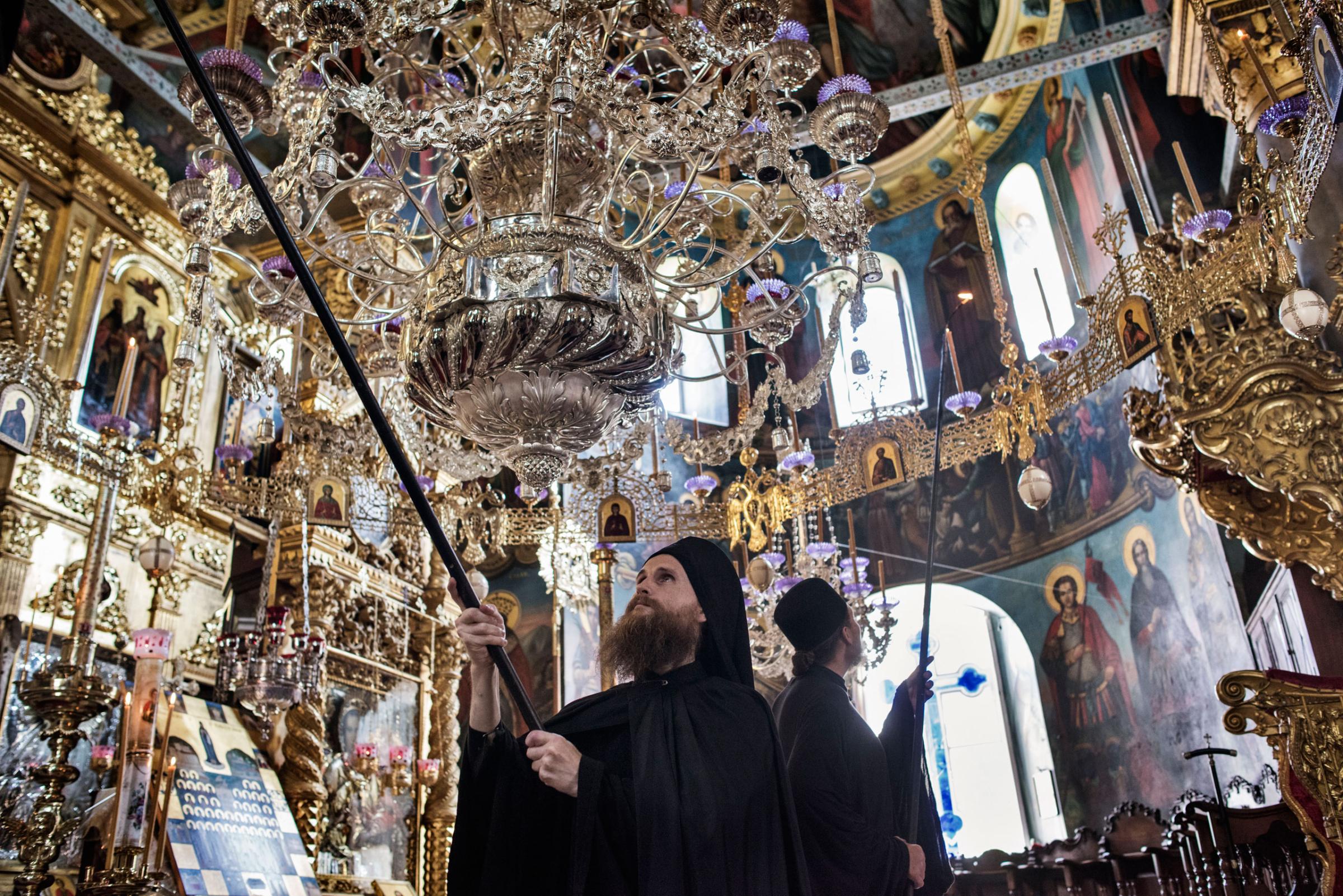 Russian Orthodox monks light candles in preparation for the arrival of Patriarch Kirill, the head of the Russian Orthodox Church, inside the Monastery of St. Panteleimon, otherwise known as Rossikon ("The Russian"), May 27, 2016.