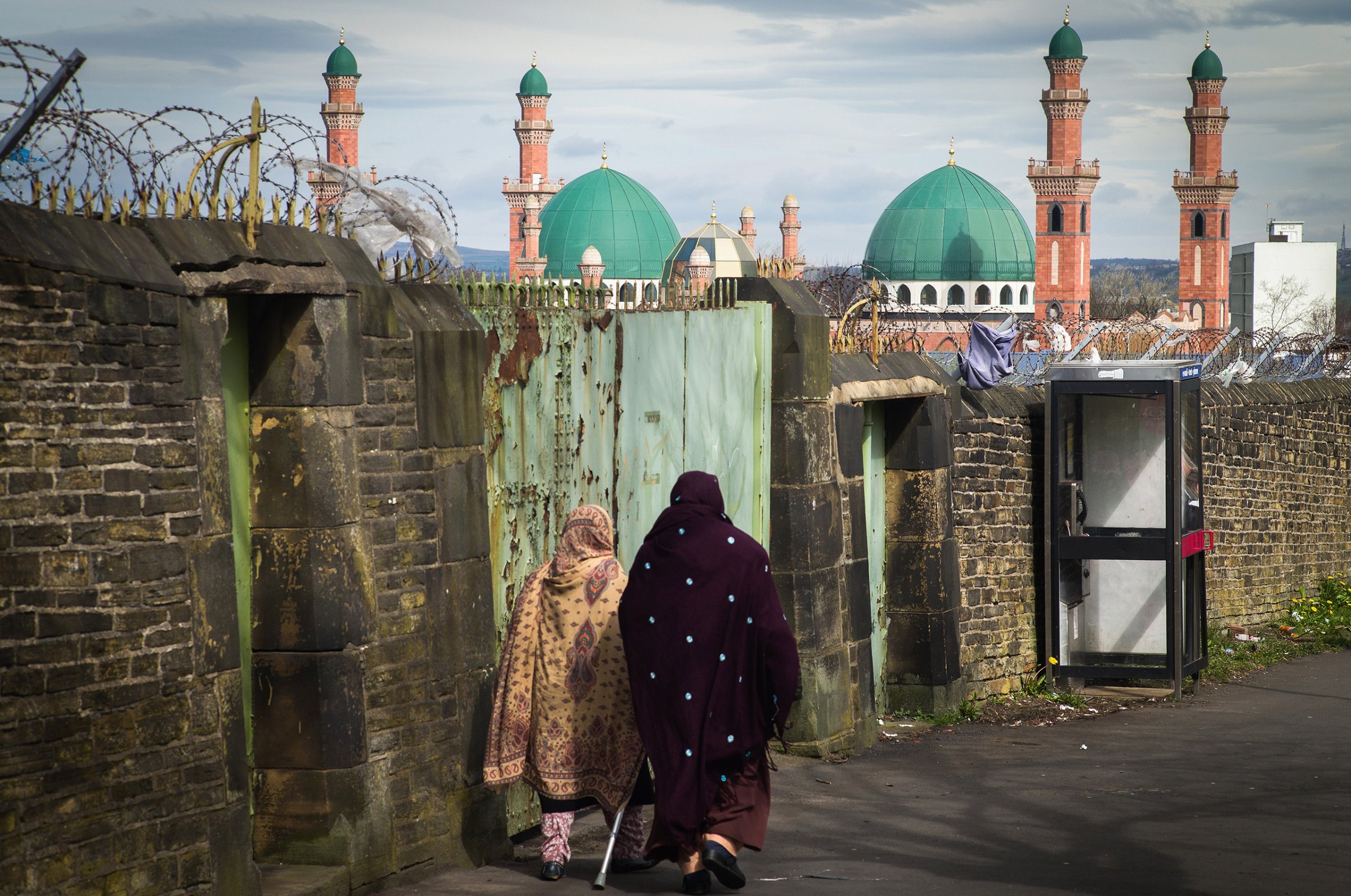 Muslim women walk in the foreground of the Suffa Tul Islam Central Mosque in the multicultural Bradford East constituency, where candidate Owais Rajput and his team canvassed ahead of May 7 elections in Bradford, England, on April 14, 2015.