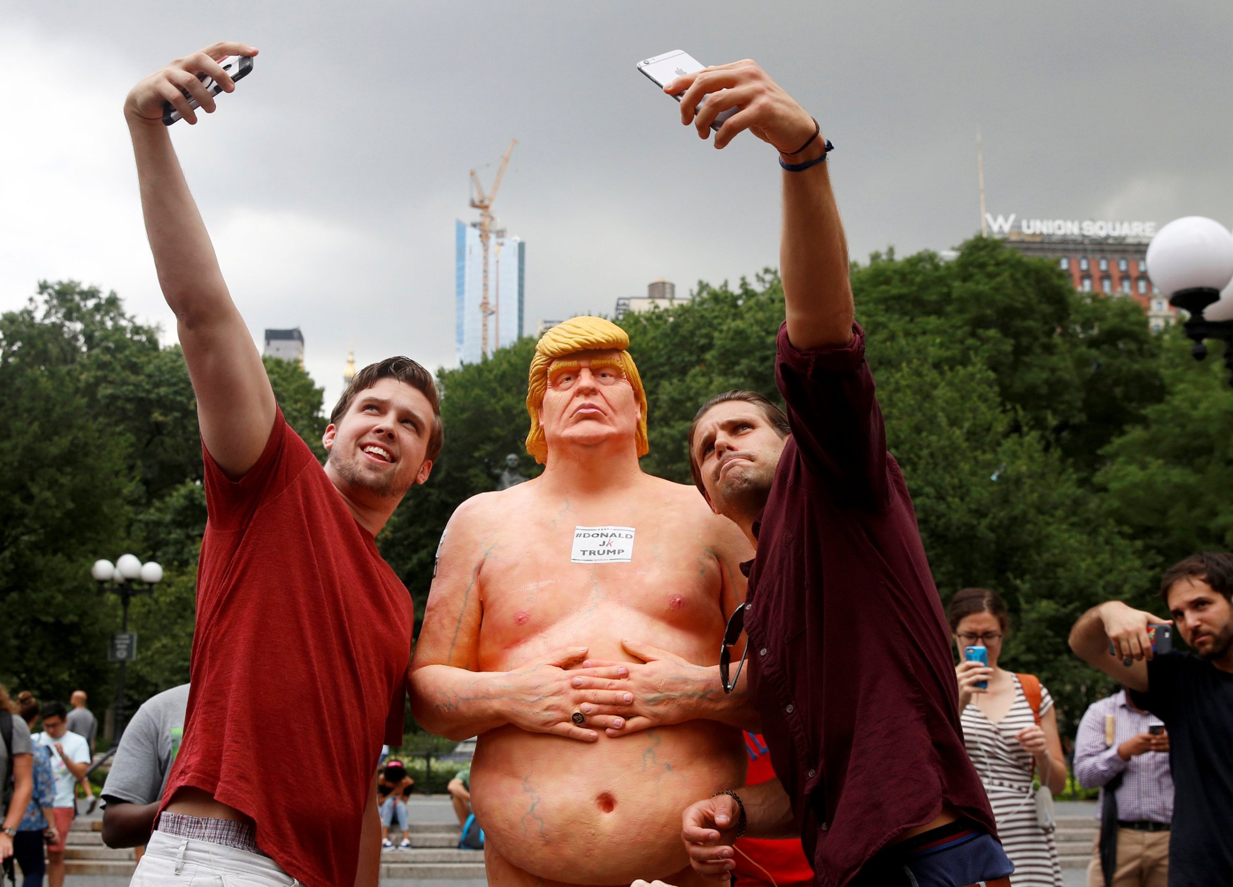 People pose for selfies with a naked statue of U.S. Republican presidential nominee Donald Trump that was left in Union Square Park in New York City on Aug. 18, 2016.