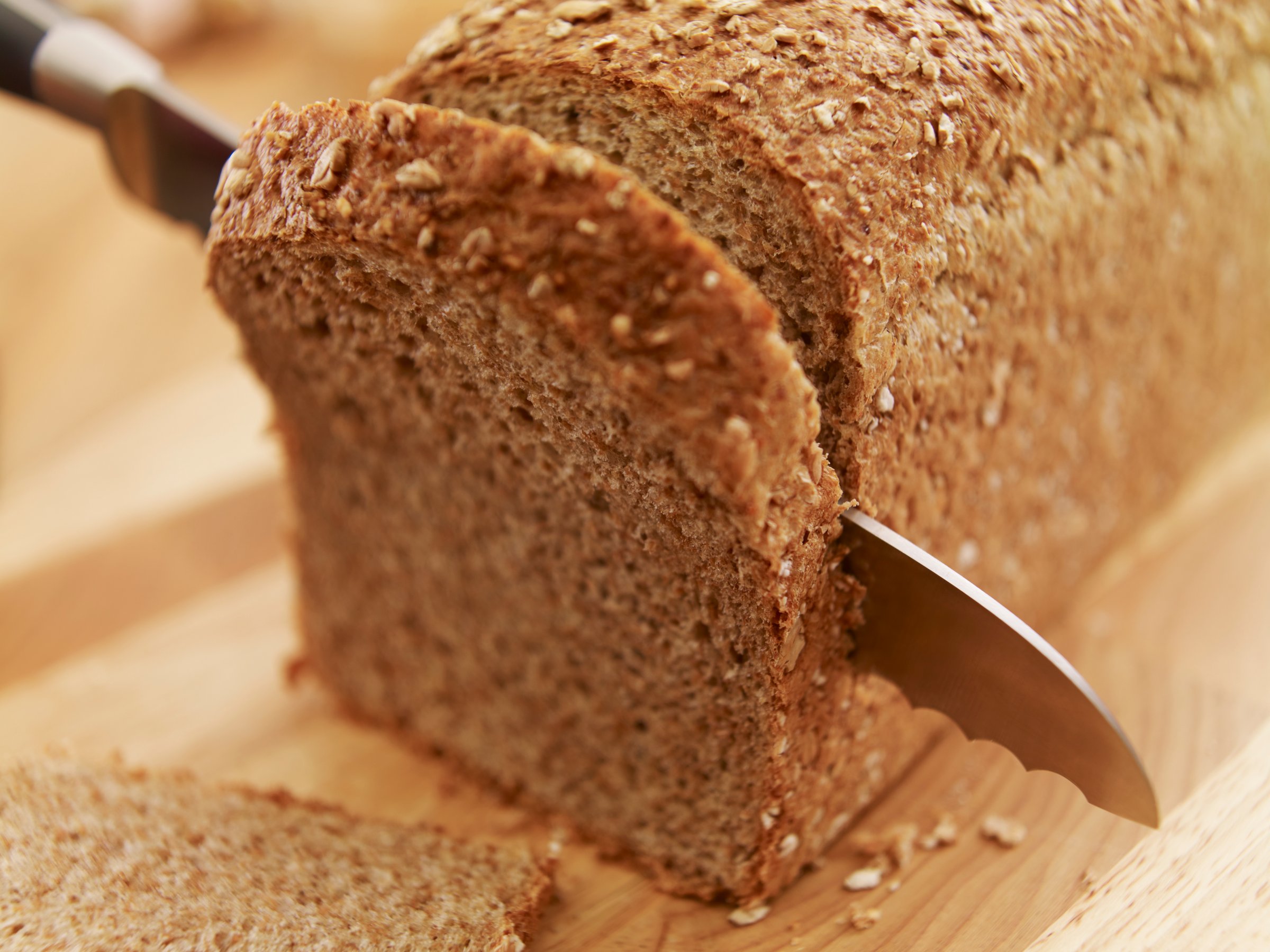 Knife slicing fresh bread loaf