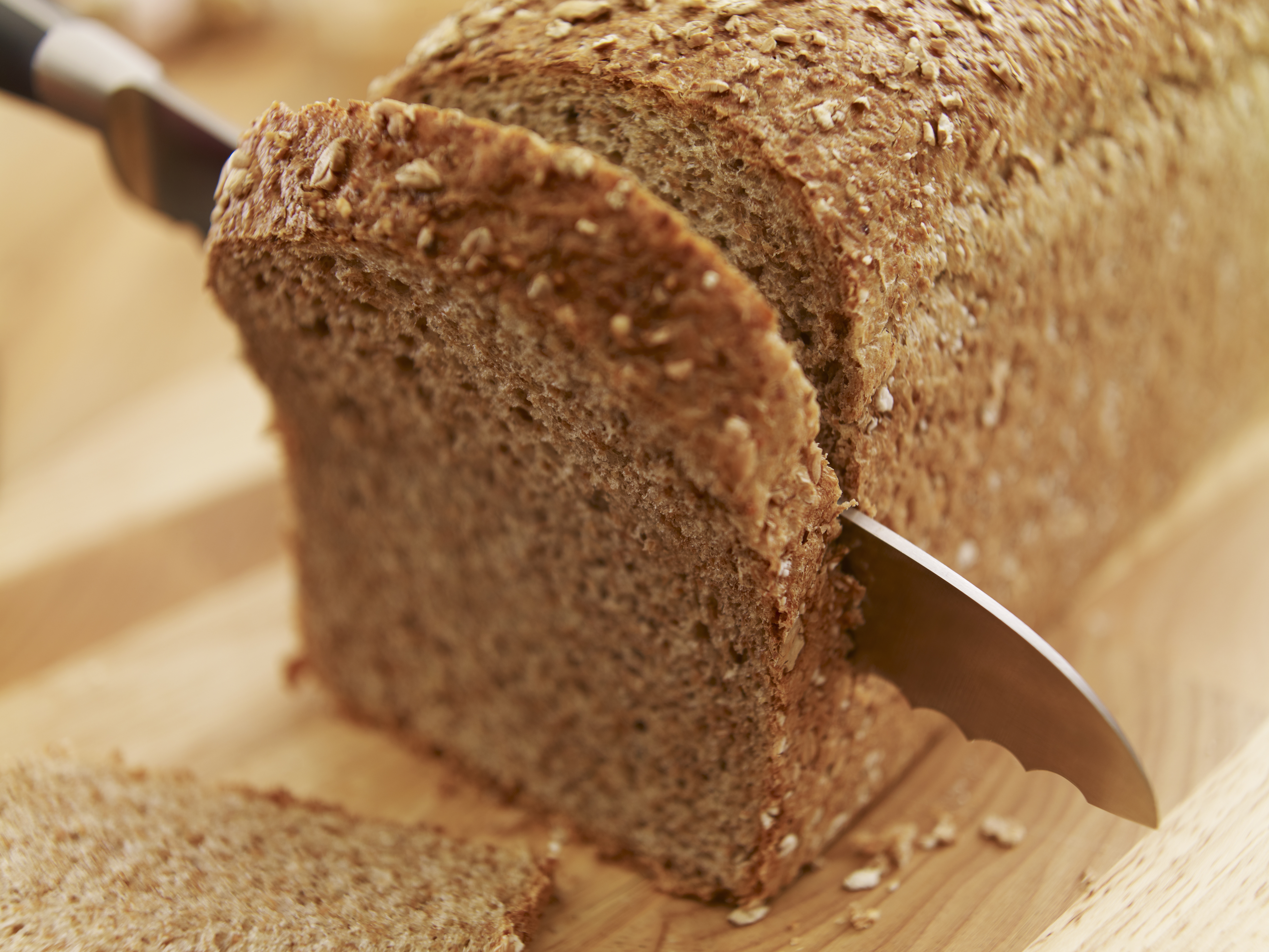 Knife slicing fresh bread loaf