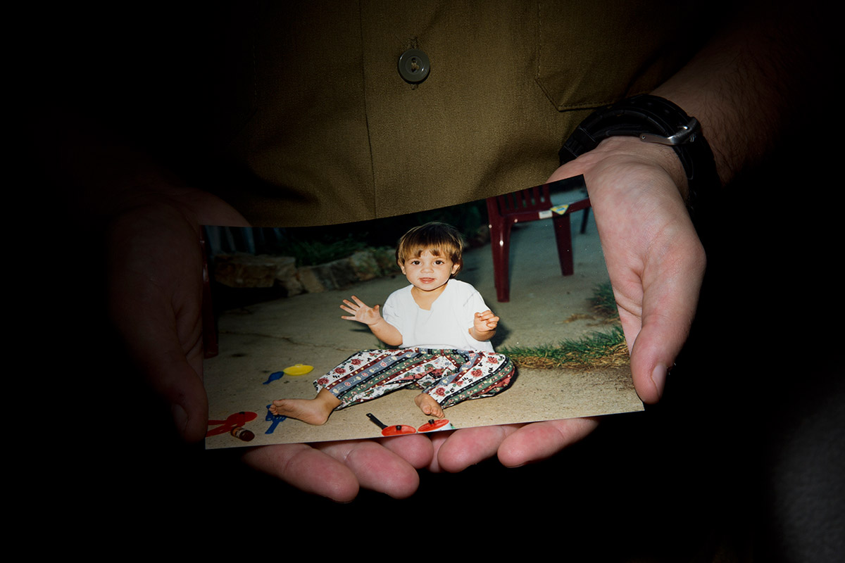 Lt. Shachar, a trans IDF officer, holds a picture of himself as a young girl in Tel Aviv, Israel, in July.