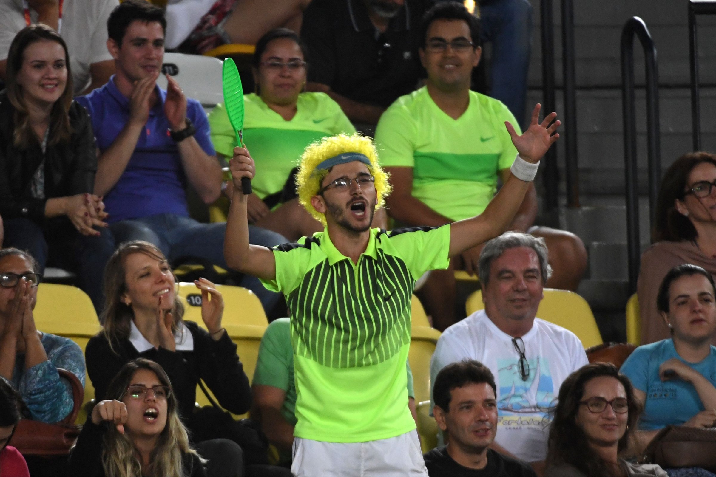 A fan wearing a green wig cheers during the men's second round singles tennis match between Japan's Kei Nishikori and Australia's John Millman at the Olympic Tennis Centre of the Rio 2016 Olympic Games in Rio de Janeiro on August 8, 2016.