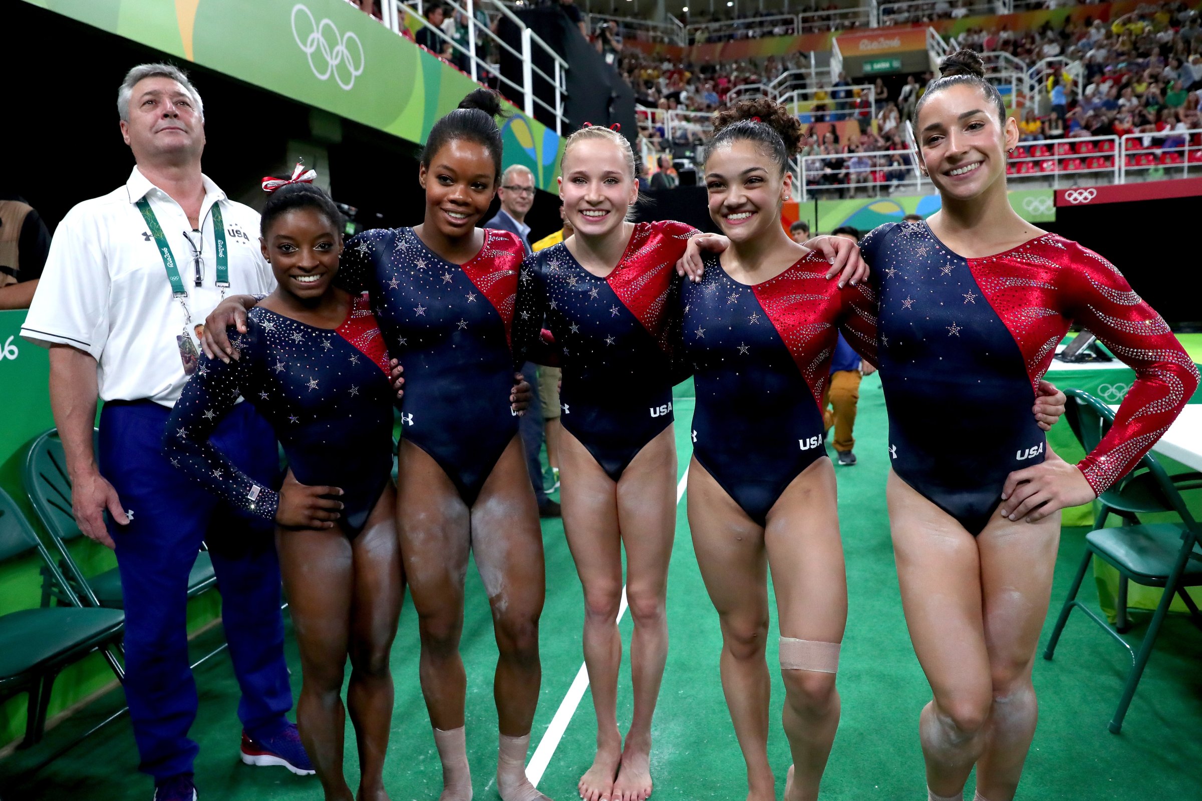 (L to R) Coach Mihai Brestyan, Simone Biles, Gabrielle Douglas, Madison Kocian, Lauren Hernandez and Alexandra Raisman of the United States pose for photographs after Women's qualification for Artistic Gymnastics on Day 2 of the Rio 2016 Olympic Games at the Rio Olympic Arena Rio de Janeiro on Aug. 7, 2016.