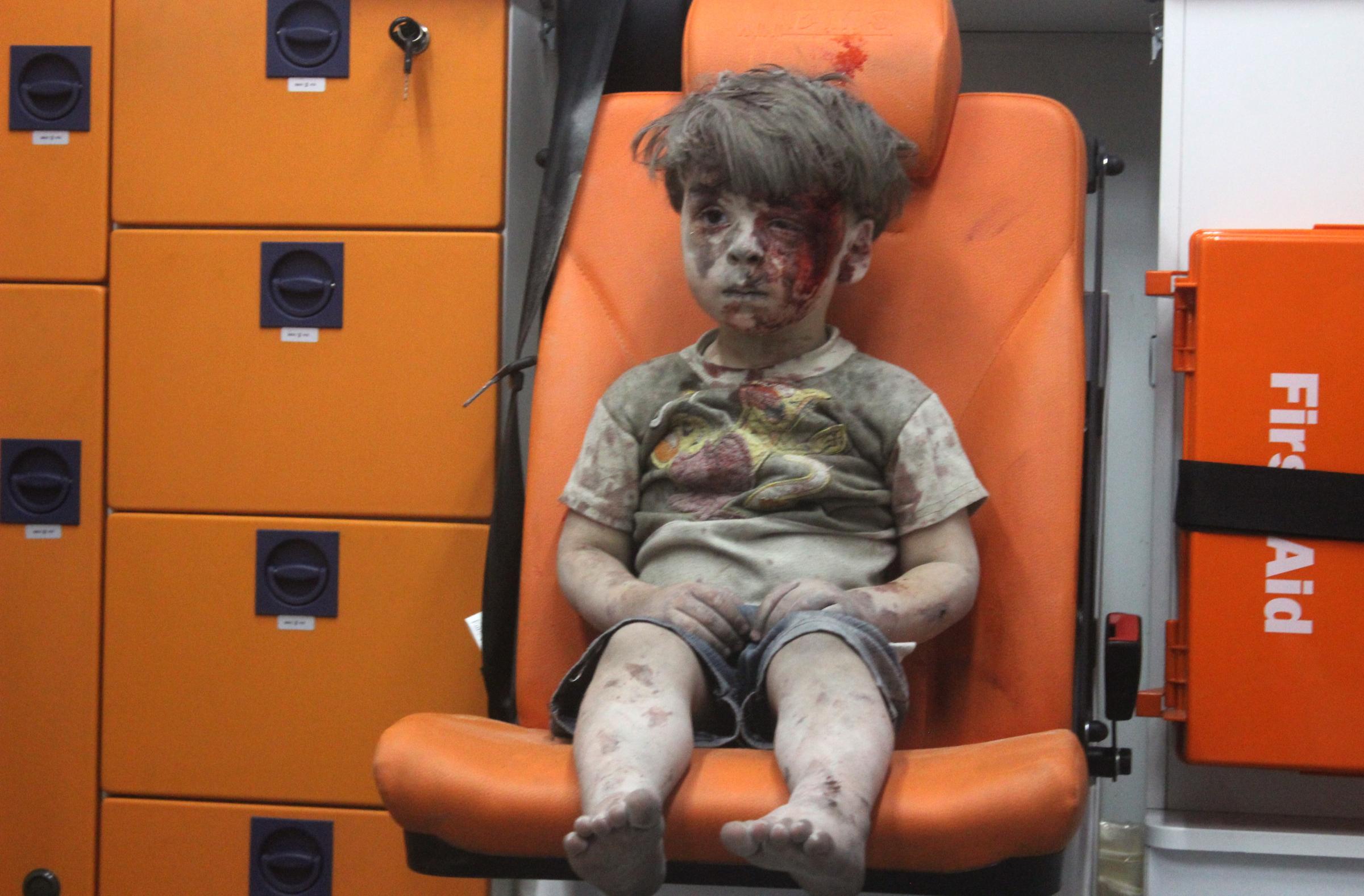 Five-year-old Syrian boy Omran Daqneesh sits alone in the back of the ambulance after he sustained injuries during an airstrike targeting the Qaterji neighborhood of Aleppo on Aug. 17, 2016.