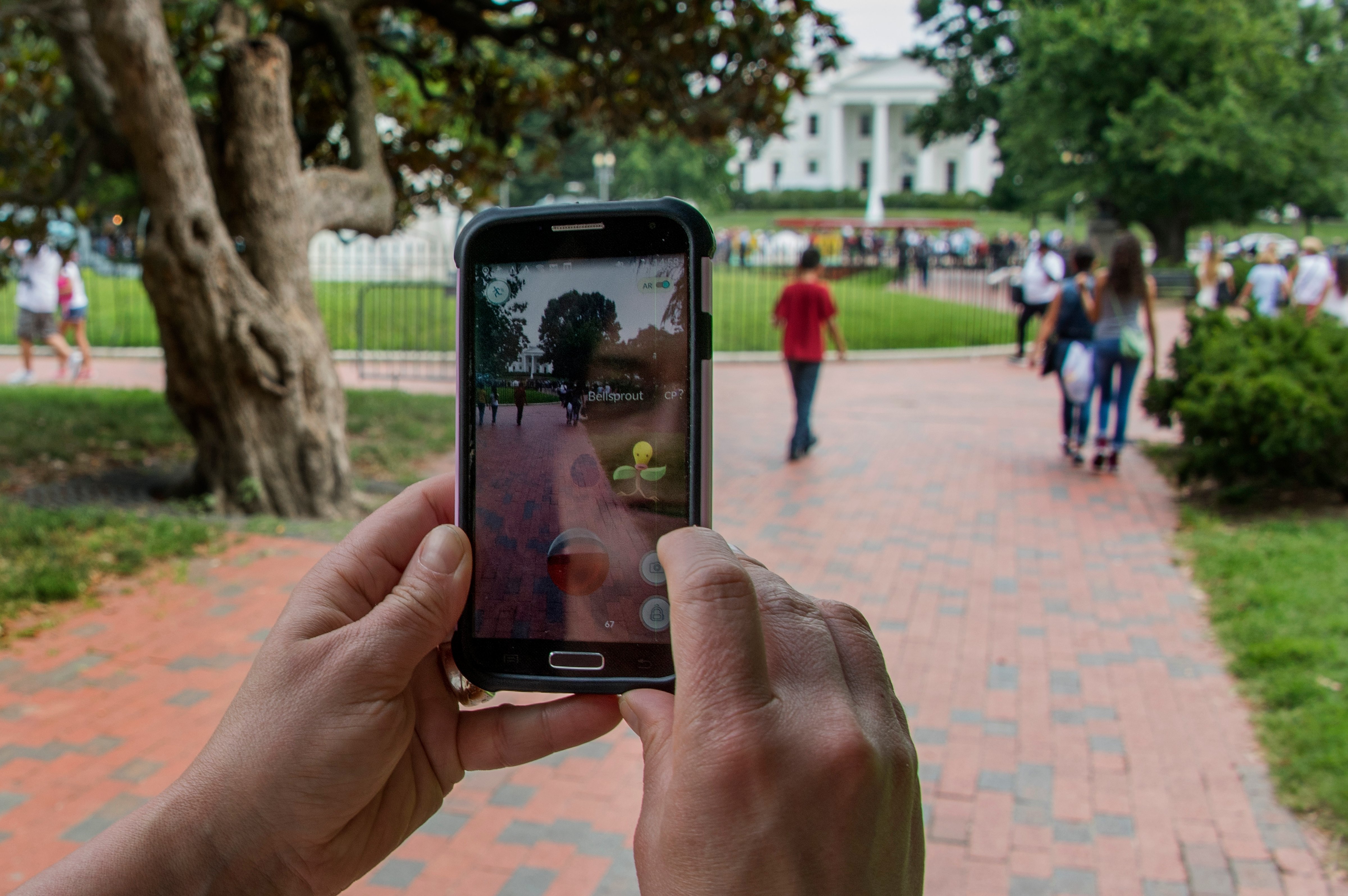 A woman plays Pokemon Go in Lafayette Park in front of the White House in Washington, DC, (Jim Watson—AFP/Getty Images)