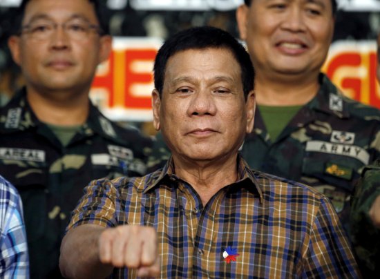 Philippine President Rodrigo Duterte makes a "fist bump", his May presidential elections campaign gesture, with soldiers during a visit at Camp Capinpin military camp in Tanay