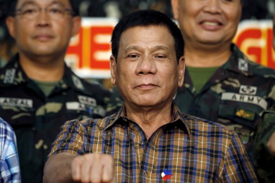 Philippine President Rodrigo Duterte makes a "fist bump", his May presidential elections campaign gesture, with soldiers during a visit at Camp Capinpin military camp in Tanay