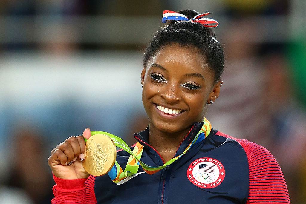 RIO DE JANEIRO, BRAZIL - AUGUST 16:  Gold medalist Simone Biles of the United States celebrates on the podium at the medal ceremony for the Women's Floor on Day 11 of the Rio 2016 Olympic Games at the Rio Olympic Arena on August 16, 2016 in Rio de Janeiro, Brazil. (Alex Livesey/Getty Images)