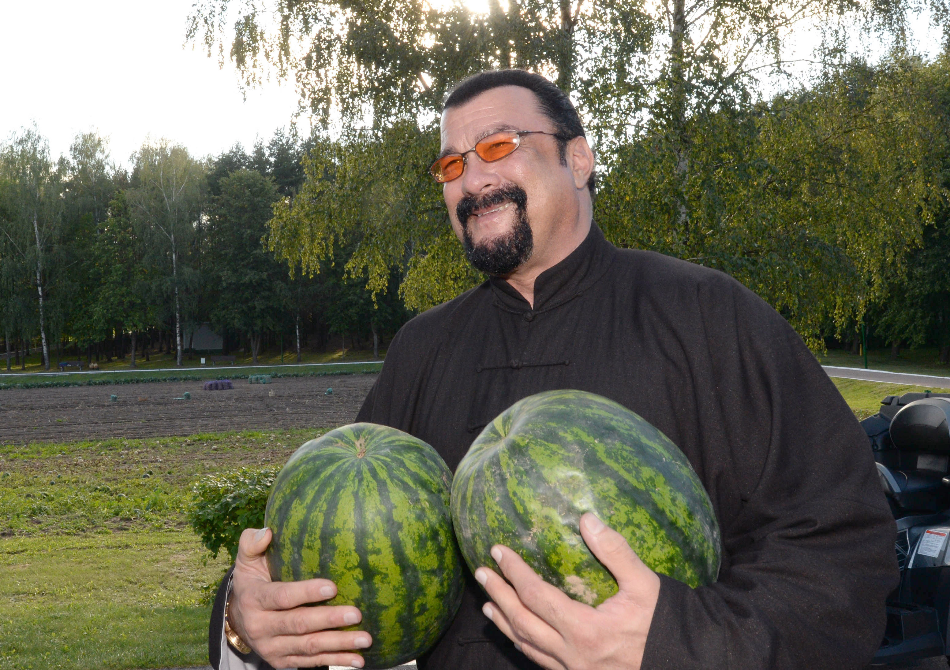U.S. actor Steven Seagal holds two water melons during his meeting with the Belarus President at his residence on August 24, 2016.