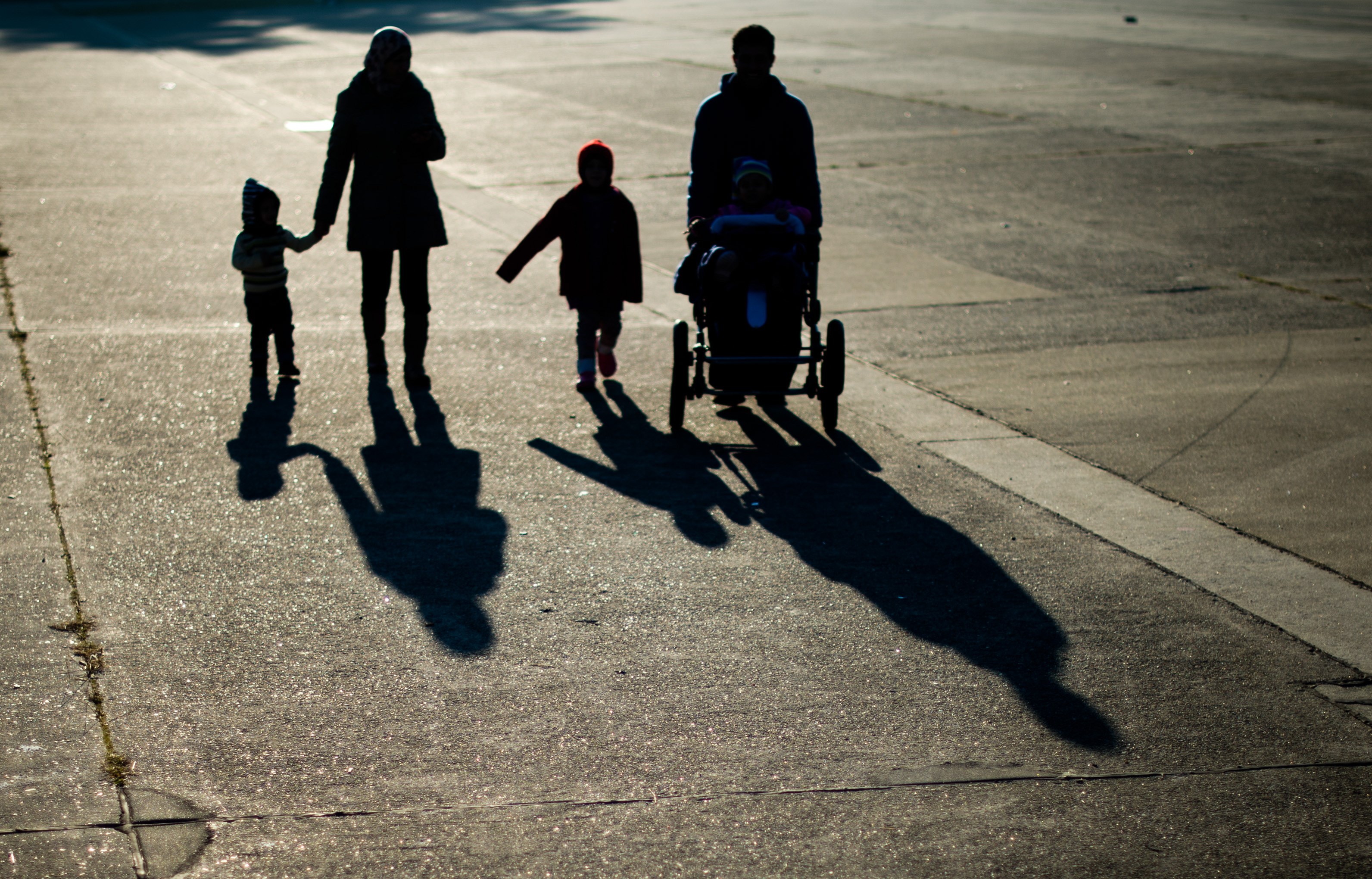 A refugee family from Syria cast long shadows as they walk  in Ehra-Lessien, in central Germany, on Nov. 3, 2015 (Julian Stratenschulte—AFP/Getty Images)