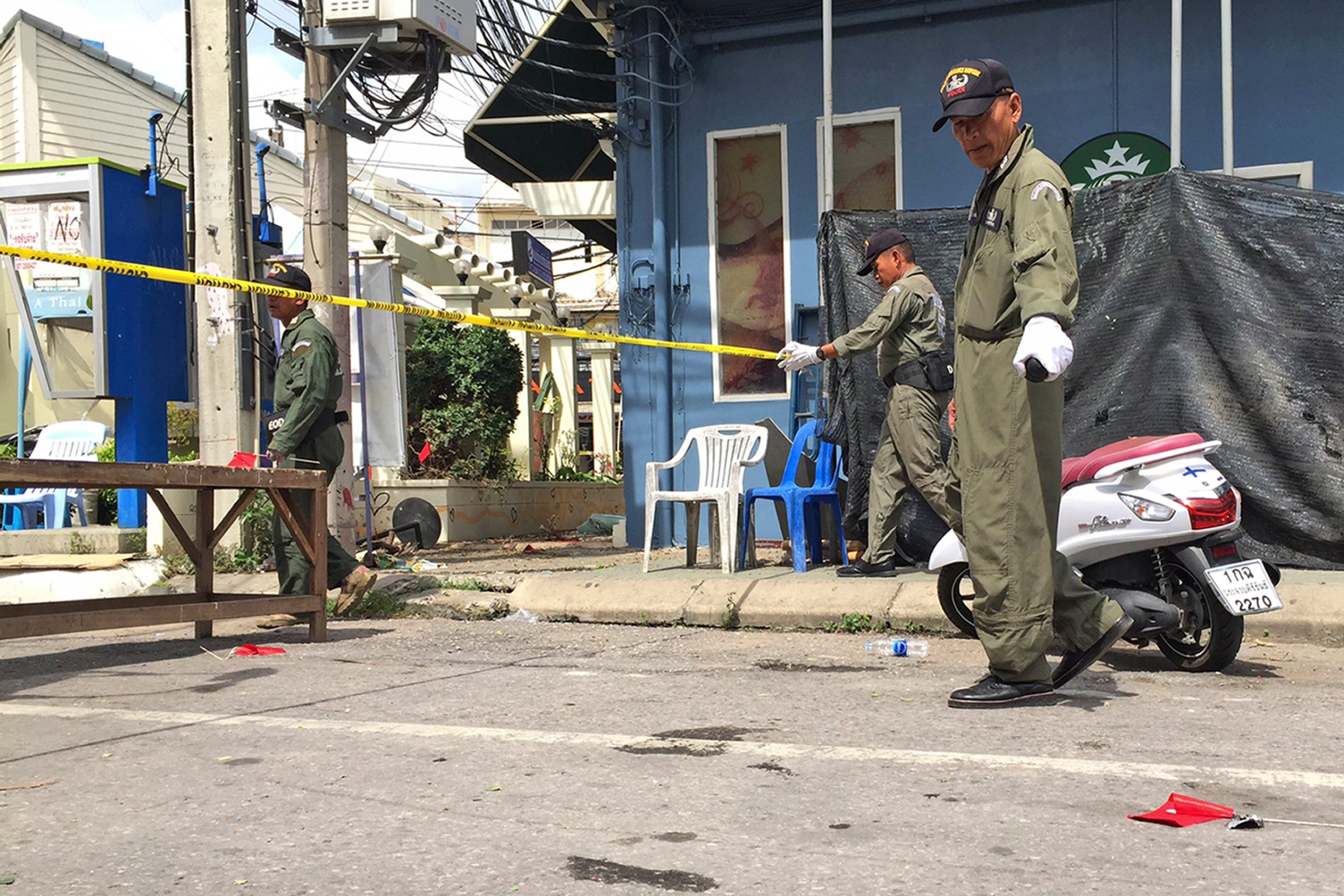 FILE - In this Friday, Aug. 12, 2016 file, investigators work at the scene of an explosion in the resort town of Hua Hin, 240 kilometers (150 miles) south of Bangkok, Thailand. Thai authorities said Monday, Aug. 15, they are investigating whether bombings last week at several popular tourist destinations were related to long-term separatist violence in the country's far south, backing away from assertions that partisan politics were behind them. (AP Photo/Jerry Harmer, File)