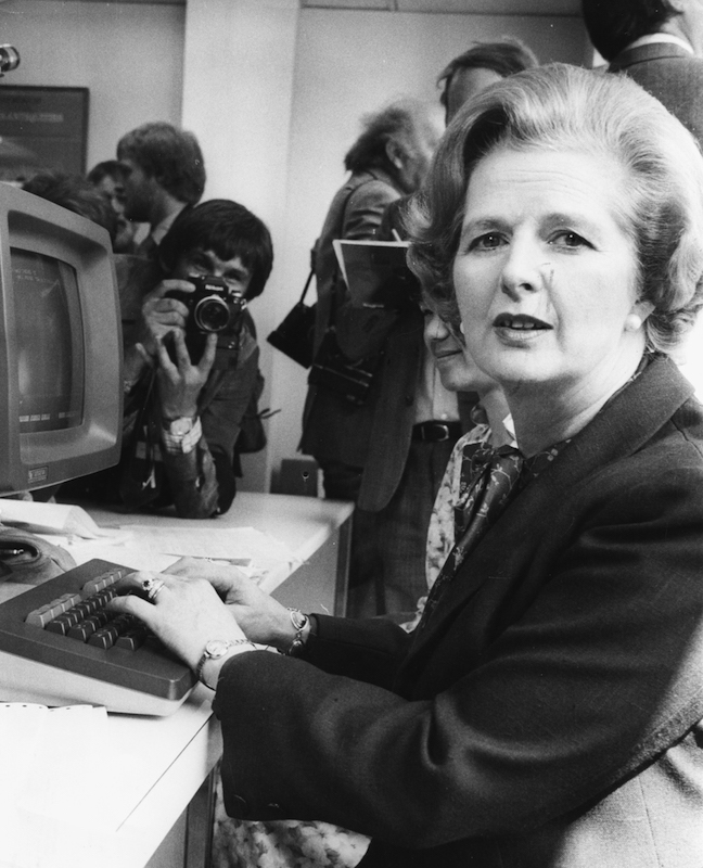 British Prime Minister Margaret Thatcher is photographed by the press as she tries out a  computer during a visit to Logica Ltd in London, 1980. (David Levenson—Getty Images)