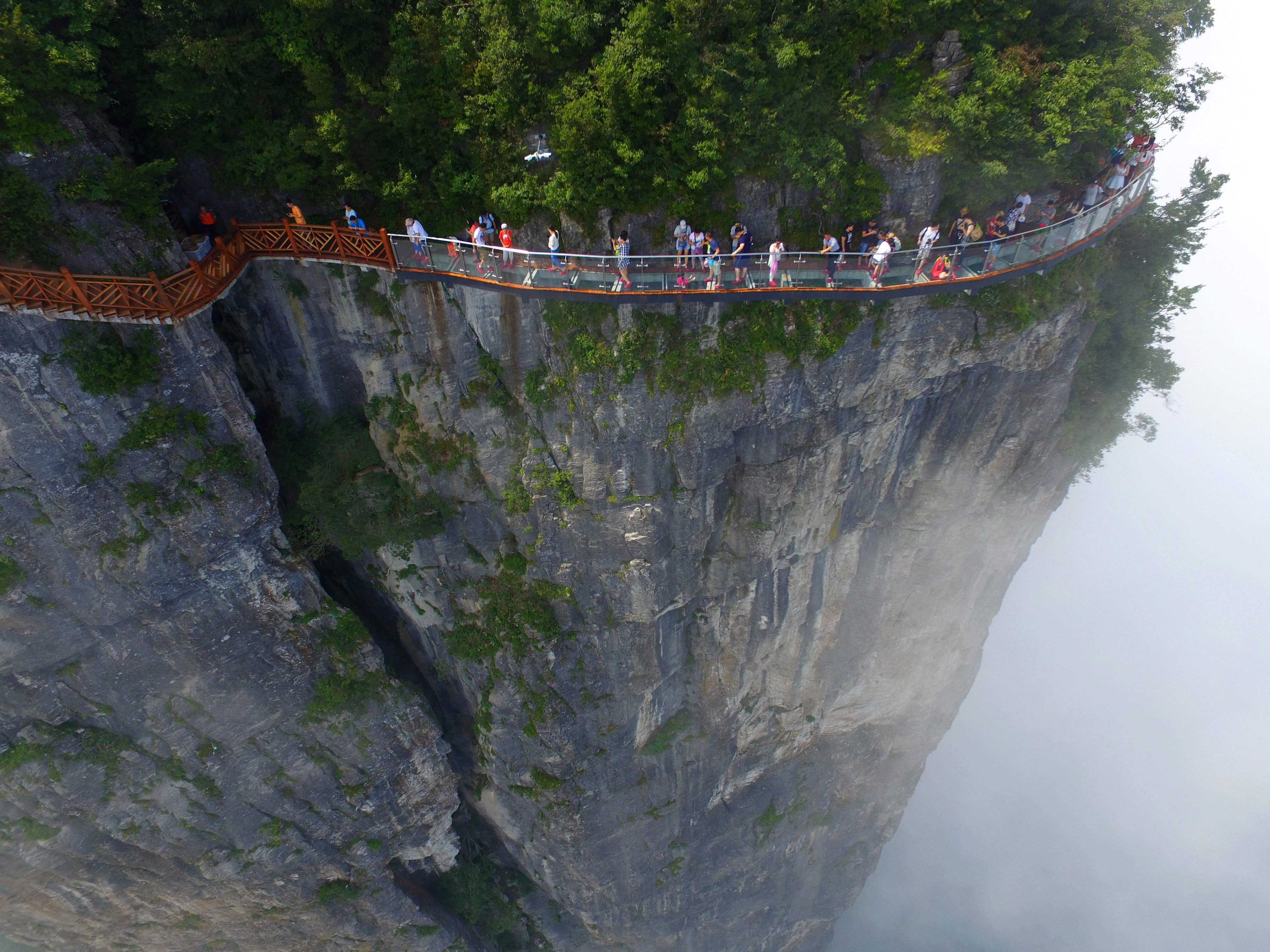 Tourists walking on the glass skywalk clung the cliff of Tianmen Mountain, on Aug. 1, 2016 in Zhangjiajie, China. (VCG/Getty Images)