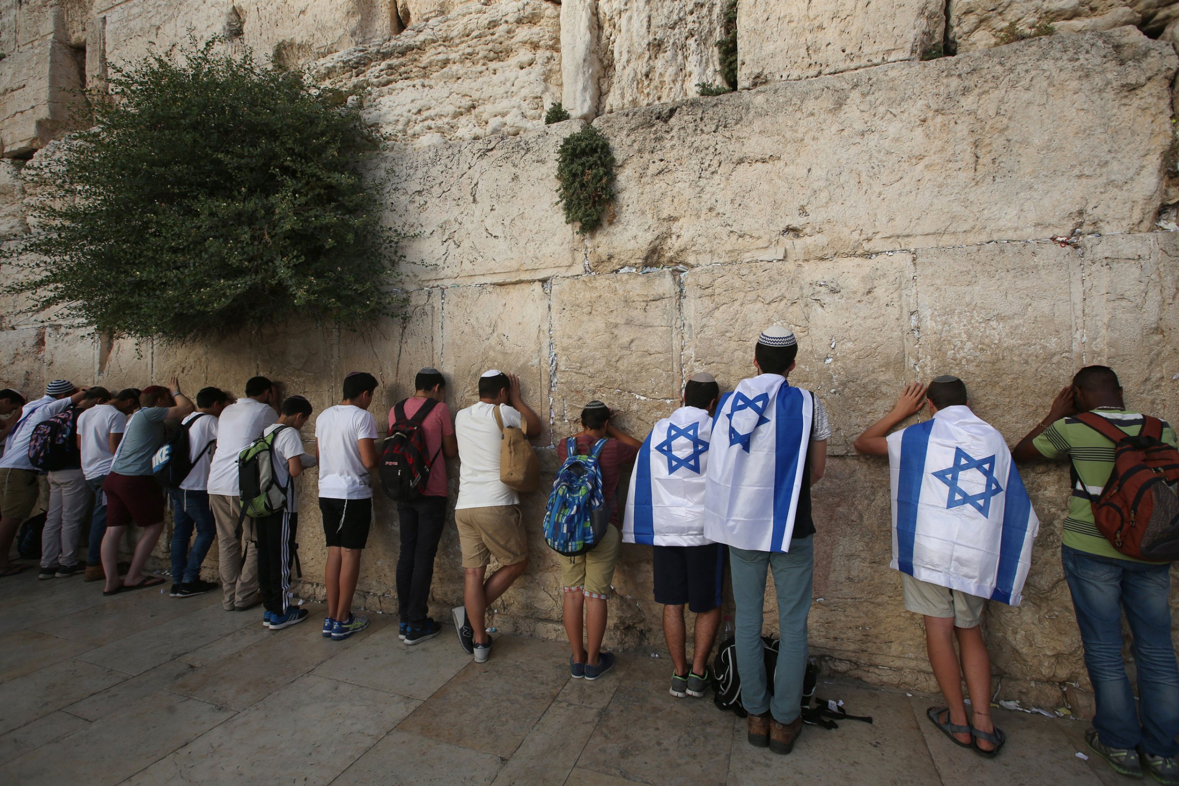 Israeli men pray at the Western Wall in Jerusalem's old city, as they celebrate Jerusalem Day, that marks the anniversary of the "reunification" of the holy city after Israel captured the Arab eastern sector from Jordan during the 1967 Six-Day War on June 5, 2016.