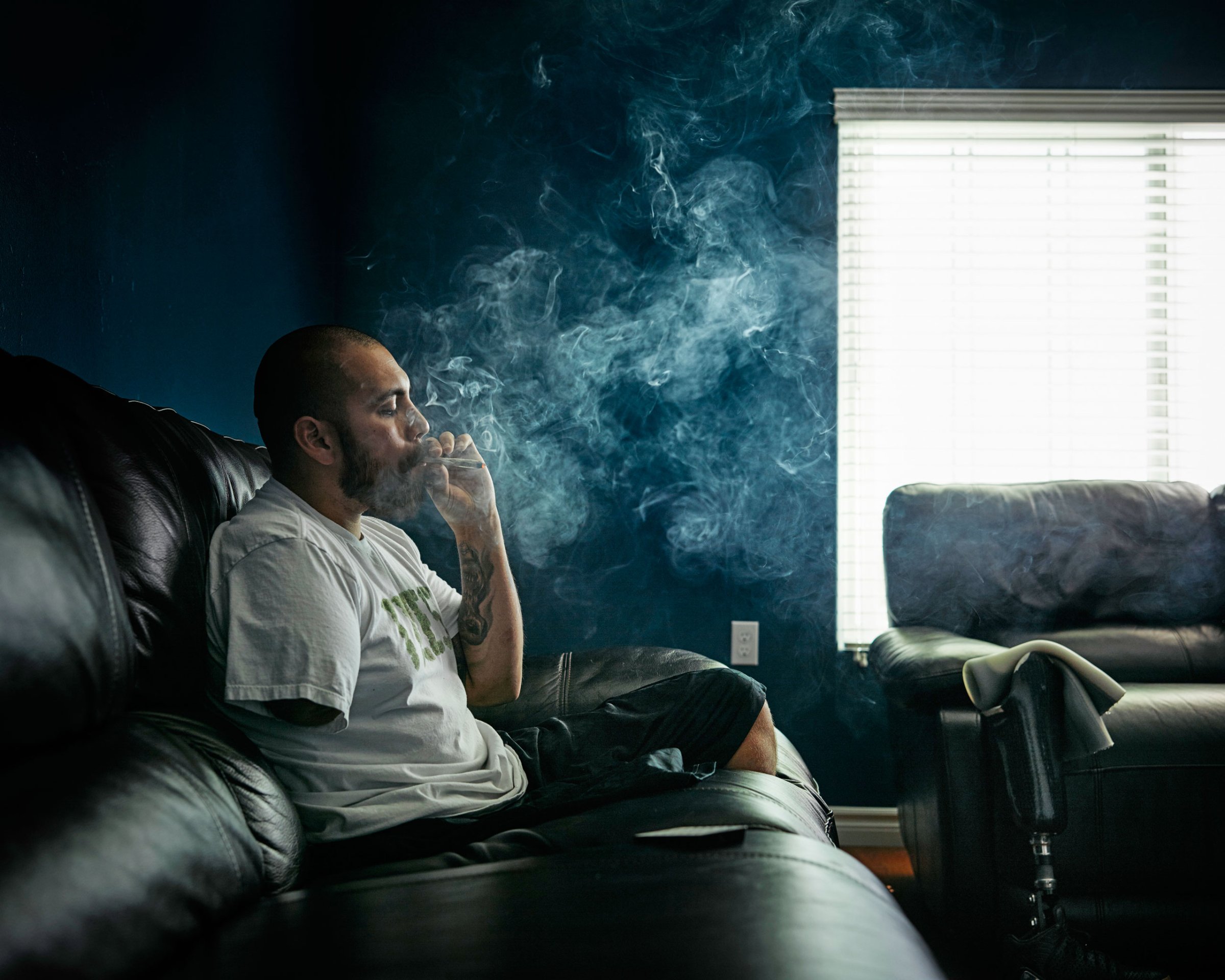 Army veteran Jose Martinez smokes marijuana in his California home; he says it eases the PTSD and pain from his 2012 trauma in Afghanistan