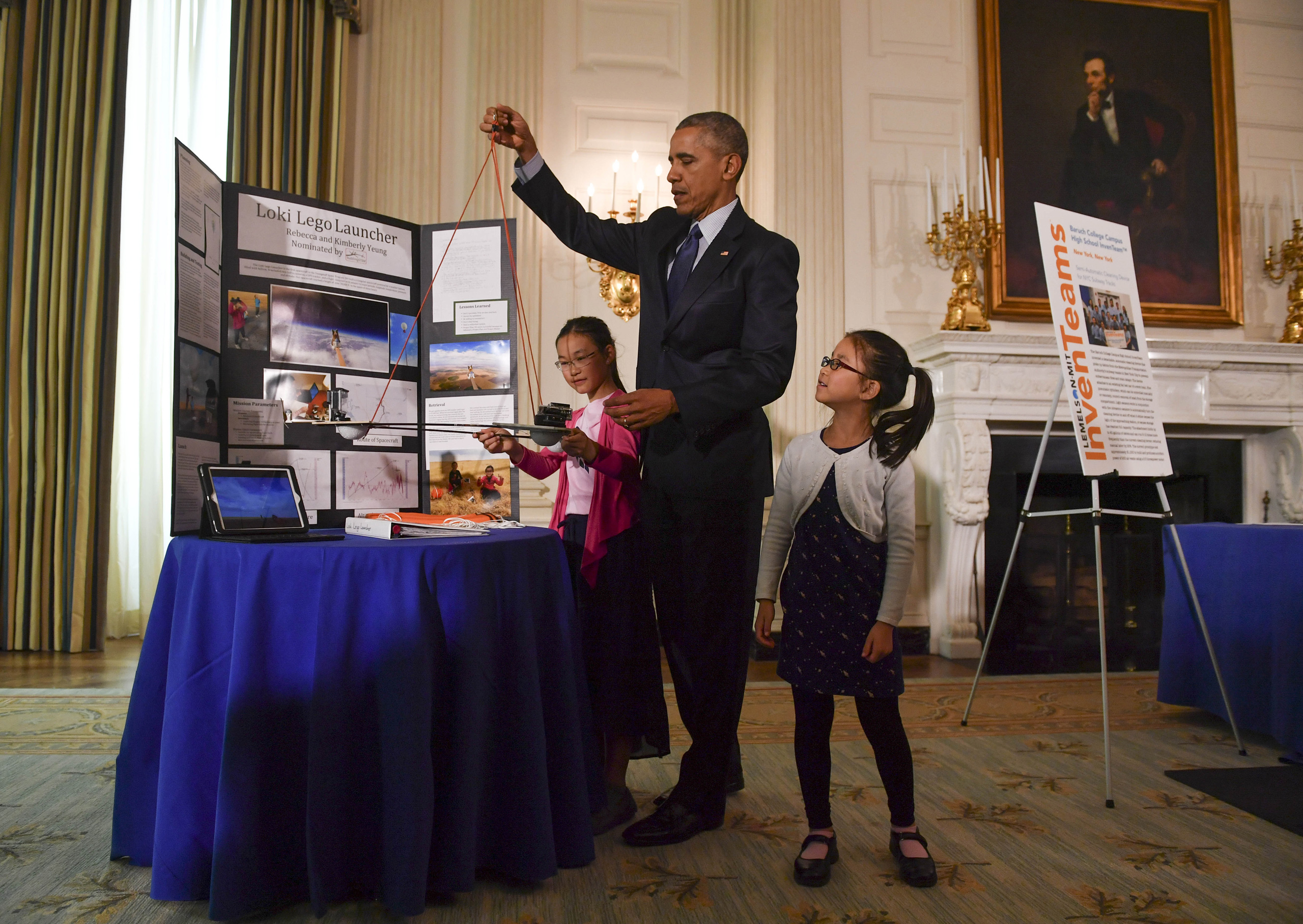 Sisters Kimberly, 9, right, and Rebecca Yeung, 11, of Seattle, WA., look on as President Barack Obama lifts their spacecraft science fair project during the sixth and final, annual White House Science Fair at The White House in Washington on April 13, 2016. (Ricky Carioti—The Washington Post/Getty Images)