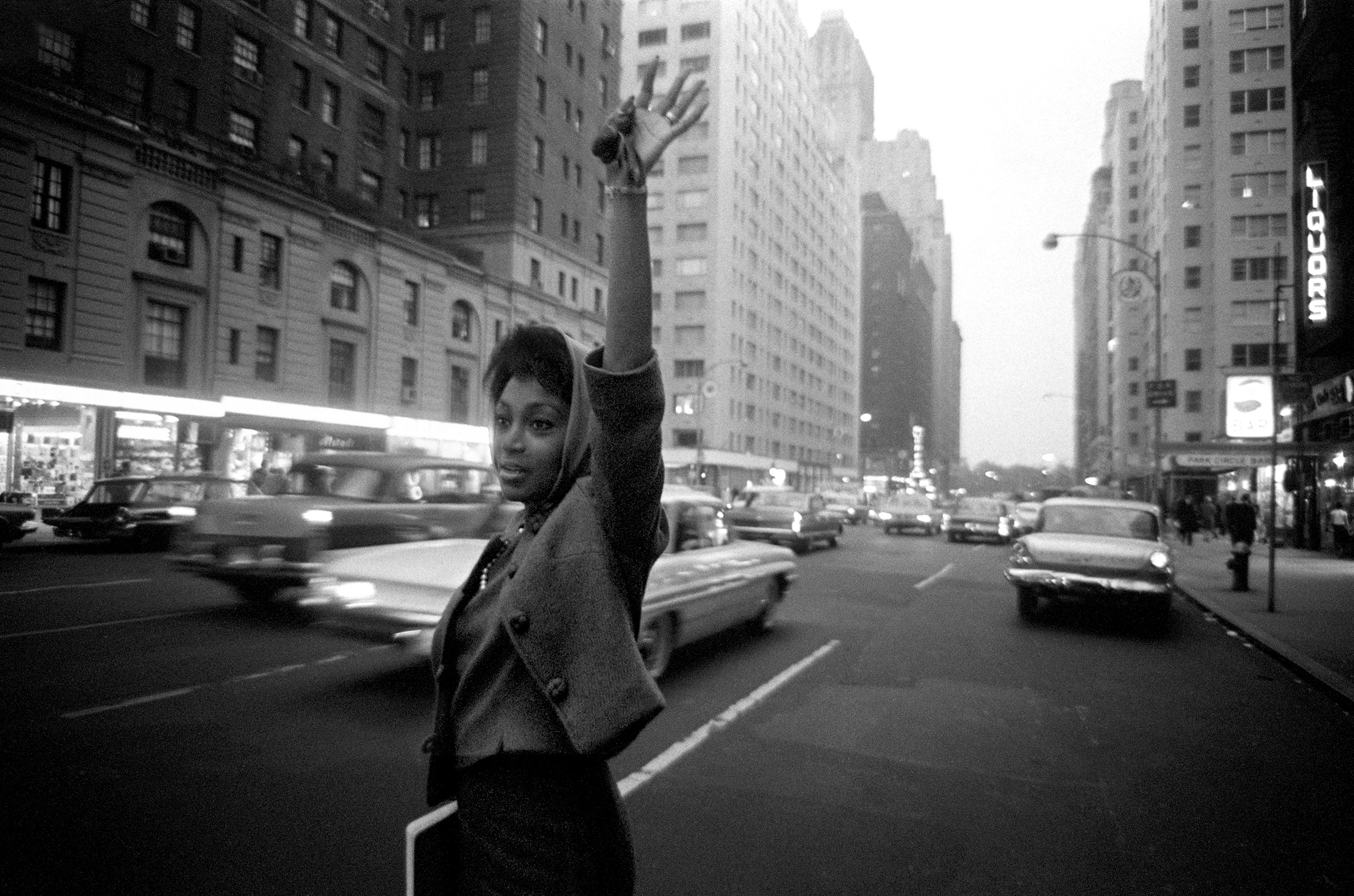 Joan Elizabeth Murray hailing a cab in Manhattan, 1963. Similar frame published in  A New Job For Joan,  LOOK 27: 25 (Dec. 17, 1963)