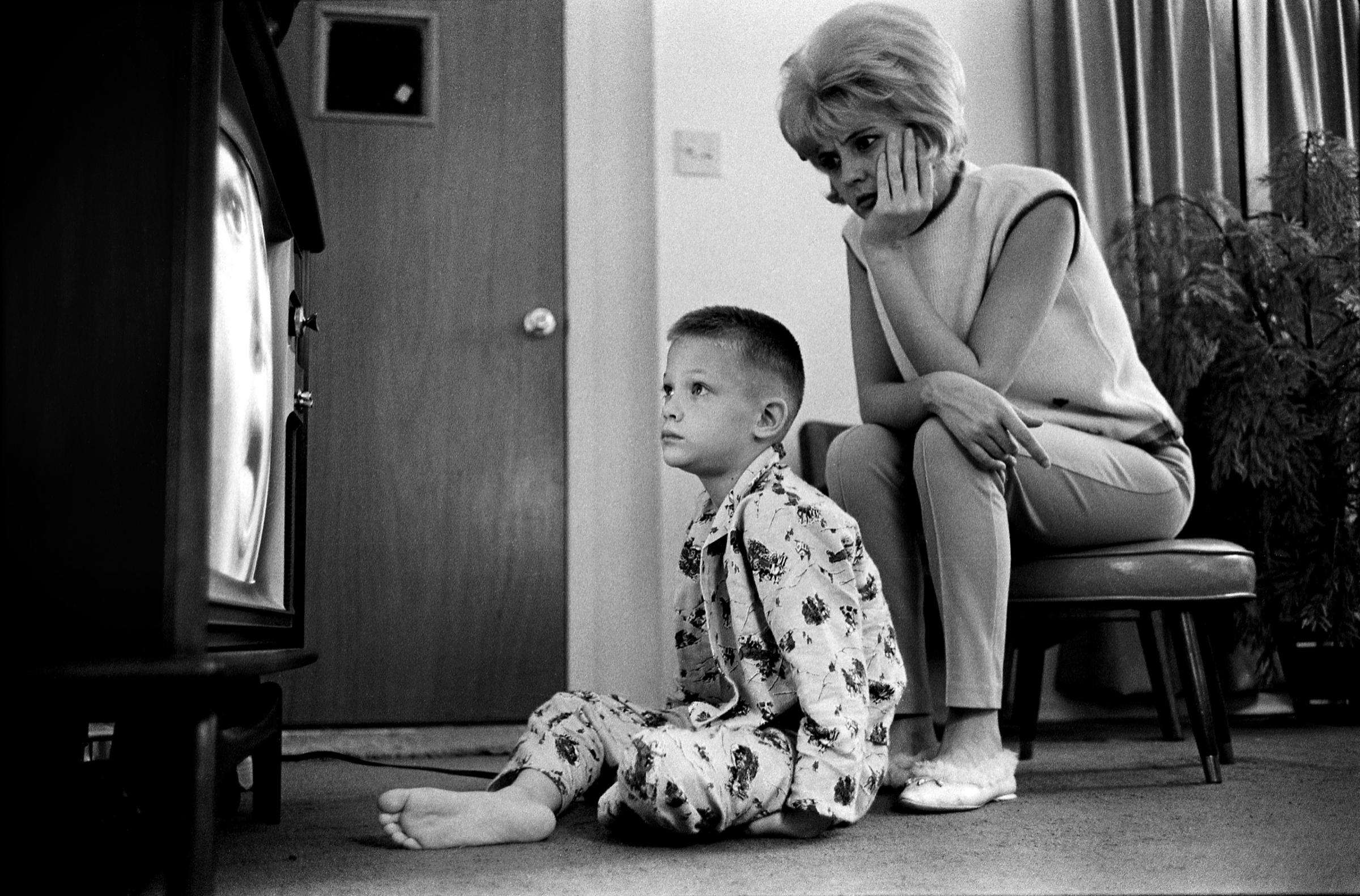 Single mother Vi Erker watching tv with her son.