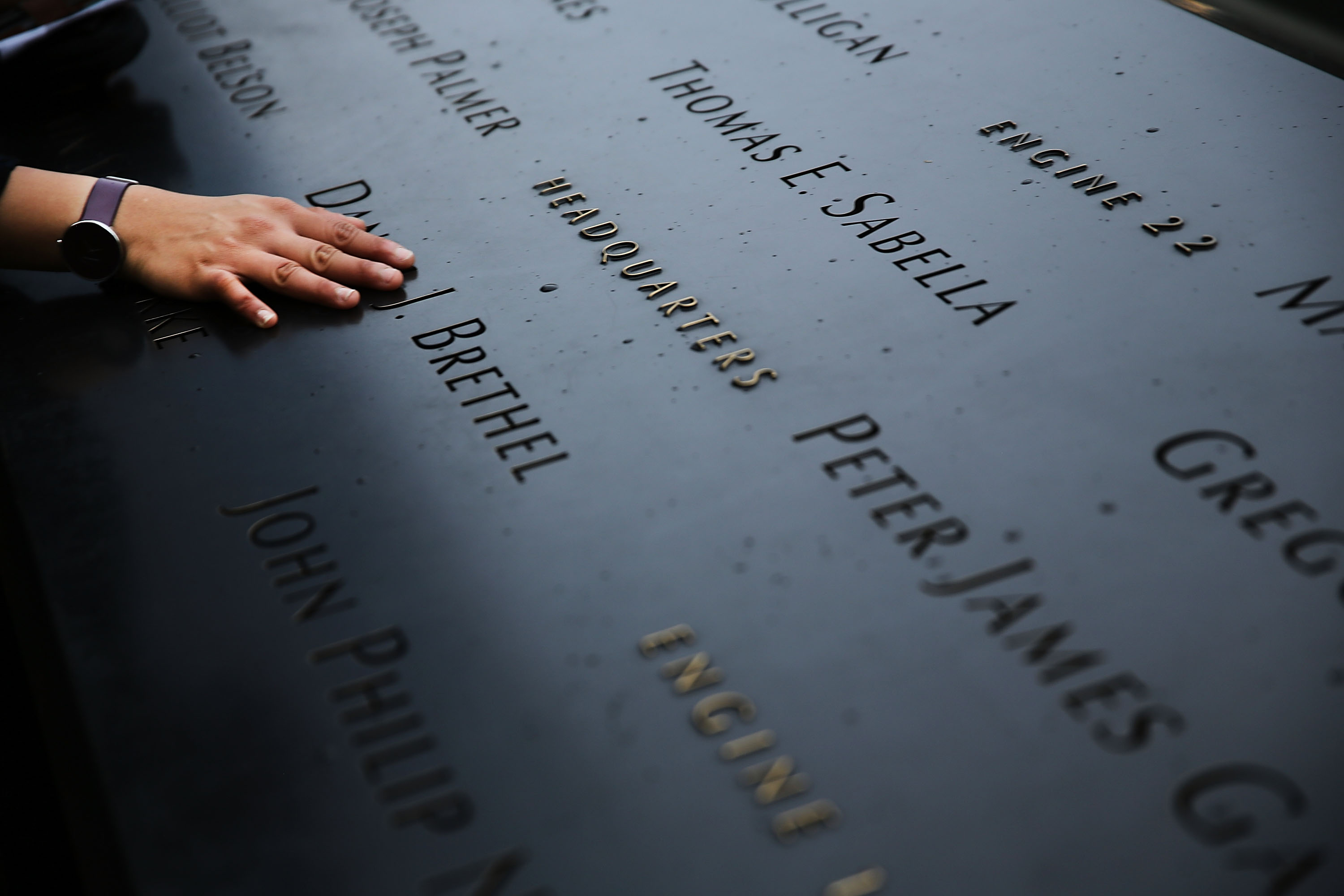 A woman places a hand on the names engraved along the South reflecting pool at the Ground Zero memorial site in New York City, on May 15, 2014. (Spencer Platt—Getty Images)
