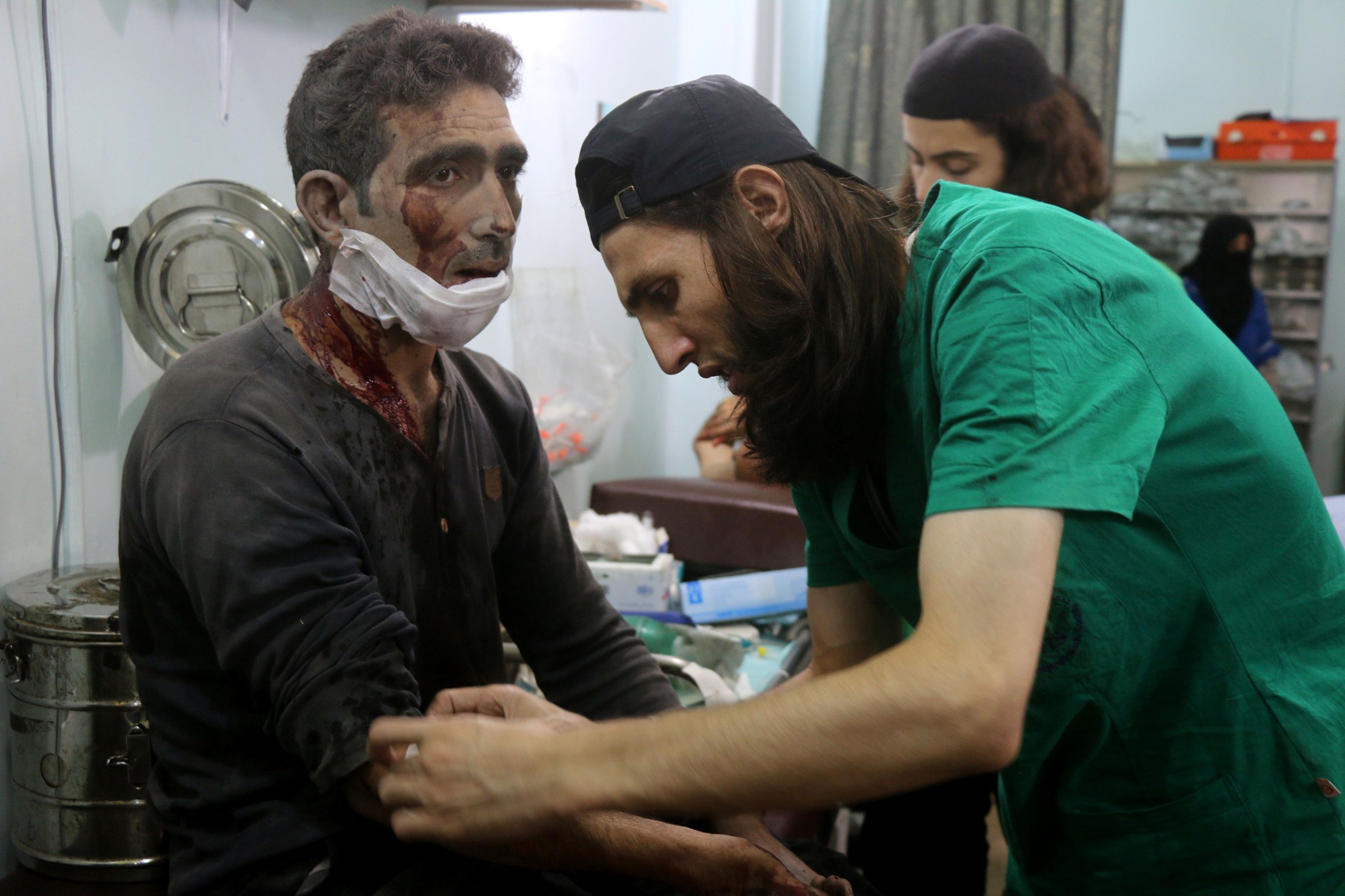 Syrian medics treat a man at a makeshift hospital in the Tariq al-Bab neighborhood of Aleppo after he was wounded during reported air raids that targeted rebel-held areas on Aug. 16, 2016.