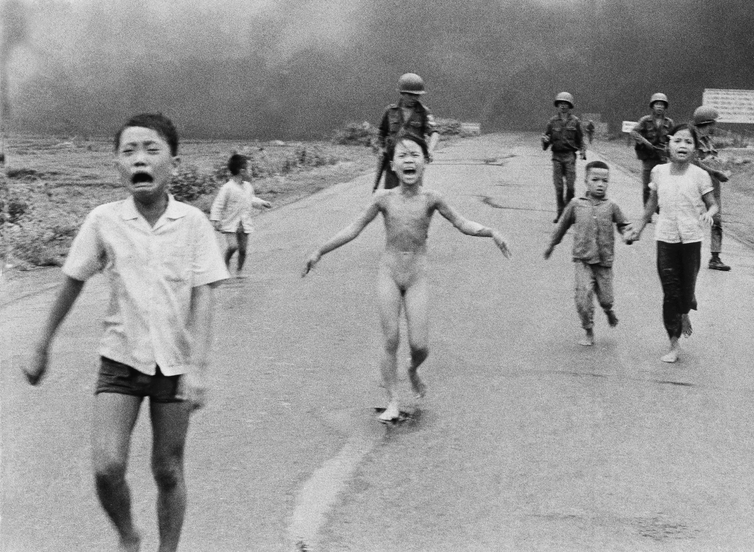 South Vietnamese forces follow after terrified children, including 9-year-old Kim Phuc, center, as they run down Route 1 near Trang Bang after an aerial napalm attack on suspected Vietcong hiding places on June 8, 1972. (Nick Ut—AP)