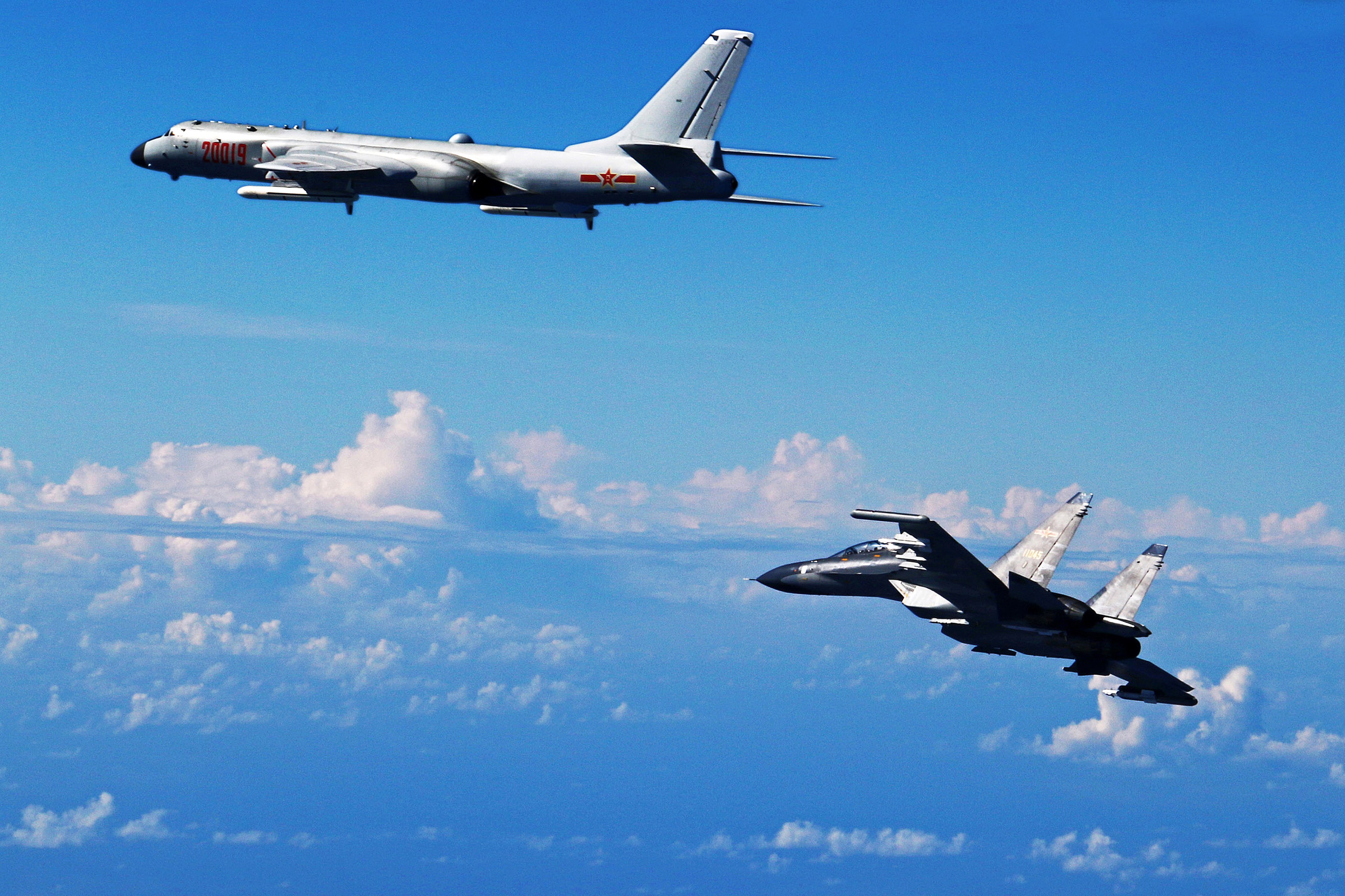 In this photo released by Xinhua News Agency, Chinese Air Force Su-30 fighter, right, flies along with a H-6K bomber as they take part in a drill near the East China Sea on Sept. 25, 2016 (Shao Jing—Xinhua/AP)