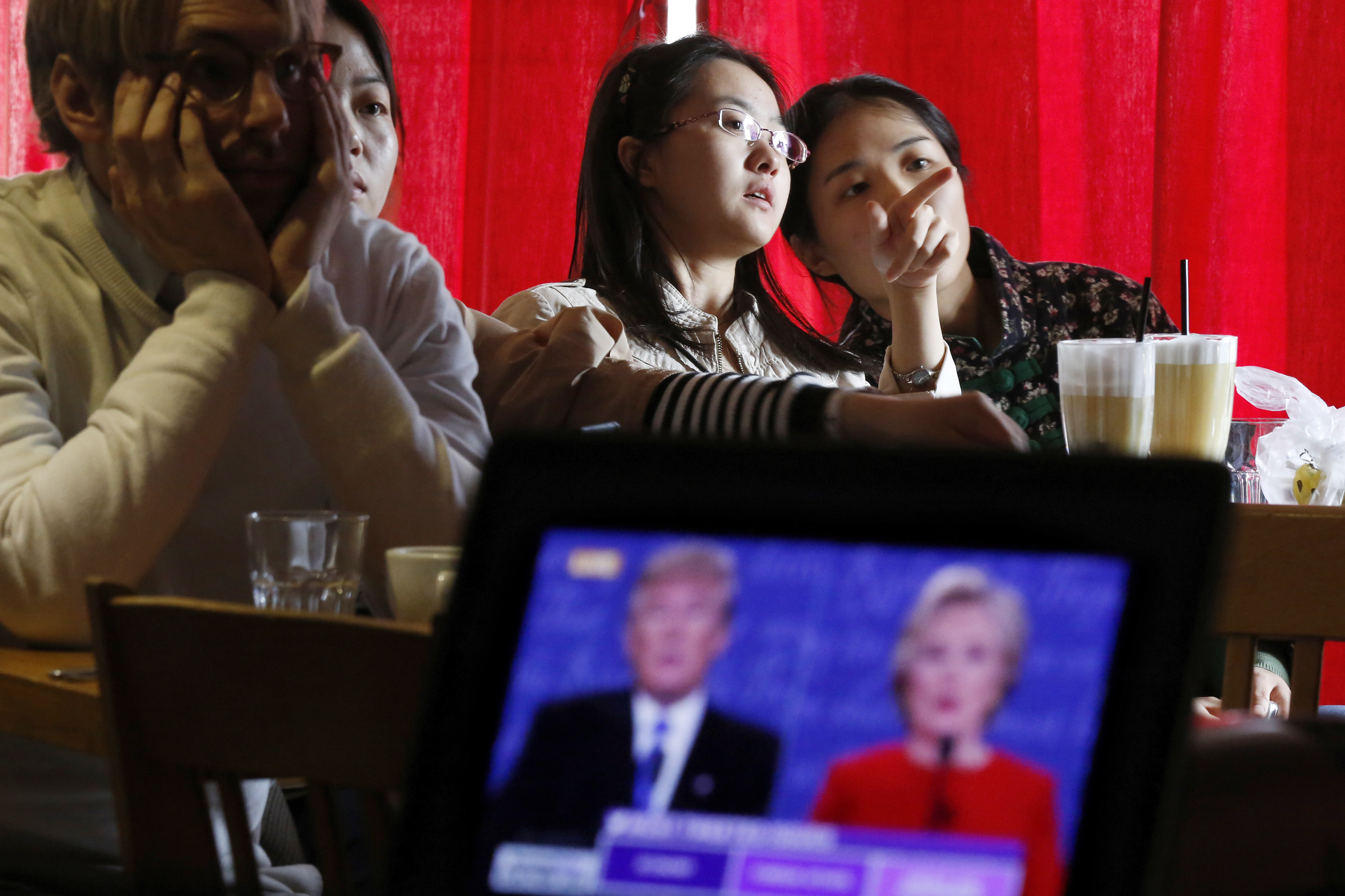 Chinese students chat as they watch a live broadcasting of the U.S. presidential debate at a cafe in Beijing on Sept. 27, 2016 (Andy Wong—AP)