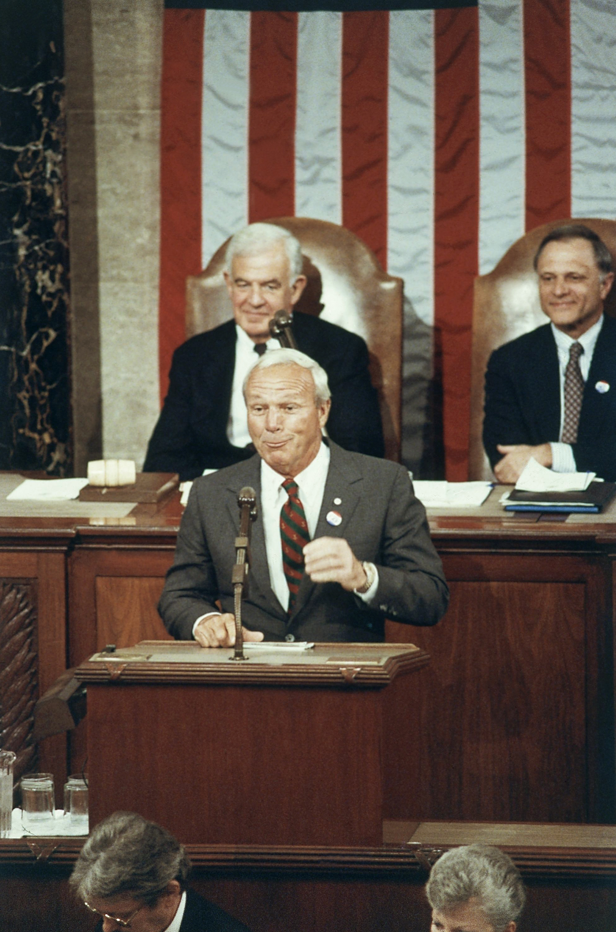 Arnold Palmer, at podium, speaks before a Joint Meeting of Congress marking the centennial of former President Dwight D. Eisenhower, on March 27, 1990, in Washington, D.C. House Speaker Tom Foley sits behind Palmer.